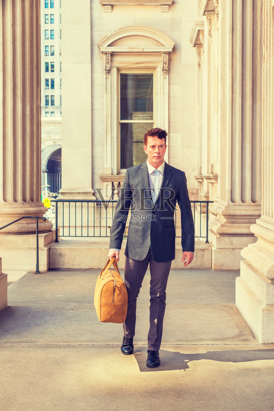 一个年轻人走在办公楼里照片摄影图片