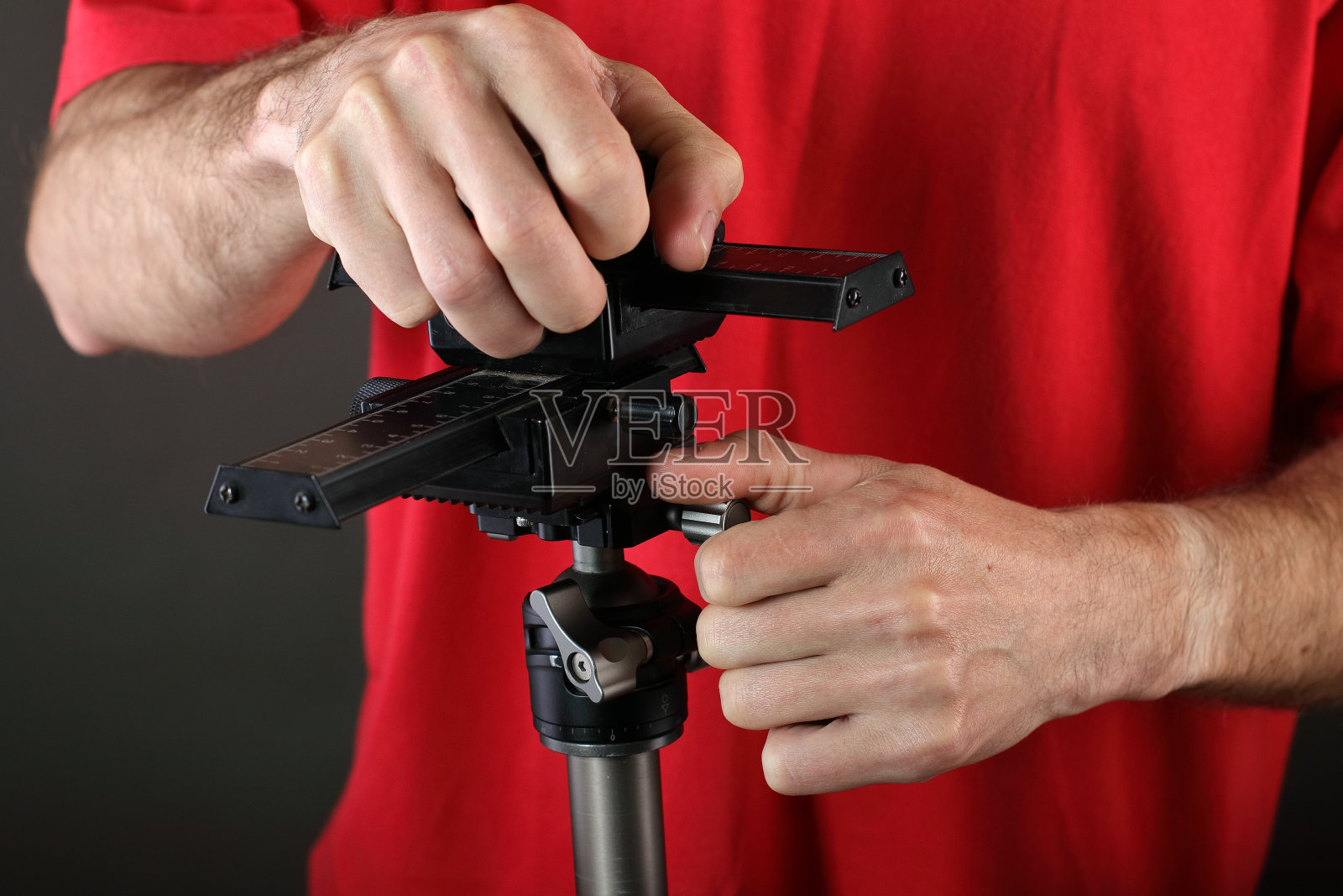 年轻男人从三脚架上取下滑轨照片摄影图片