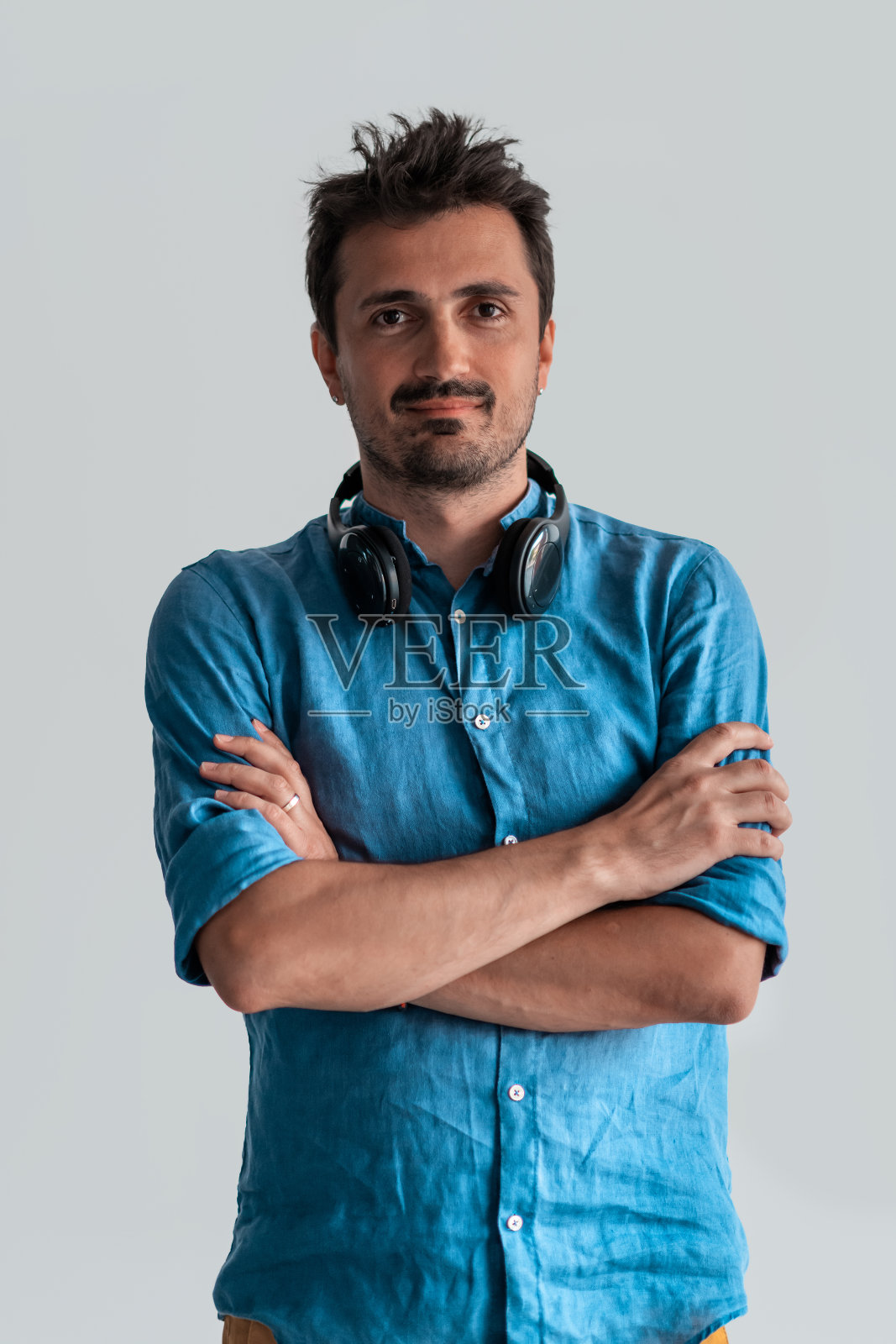 正式的商业男性肖像。一个自信的成功商人或经理站在白色背景前,双臂交叉,直视镜头,友好地微笑。高质量的摄影照片摄影图片