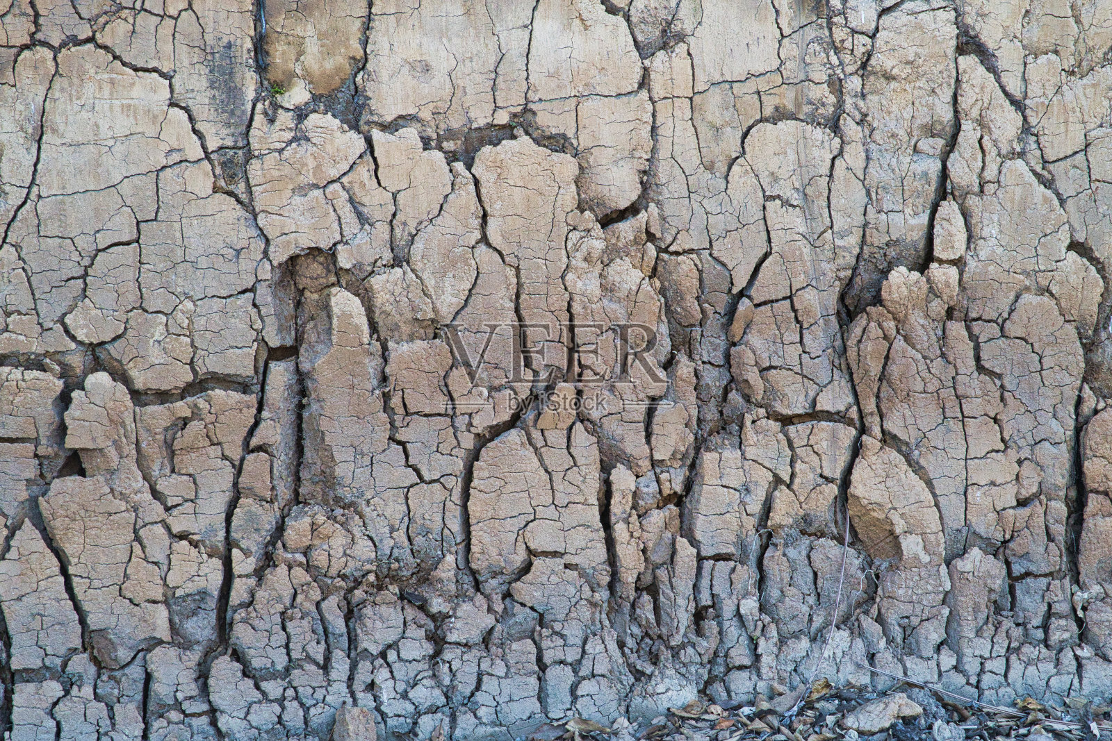 乡村公路旁的粘土墙的裂缝和裂缝照片摄影图片