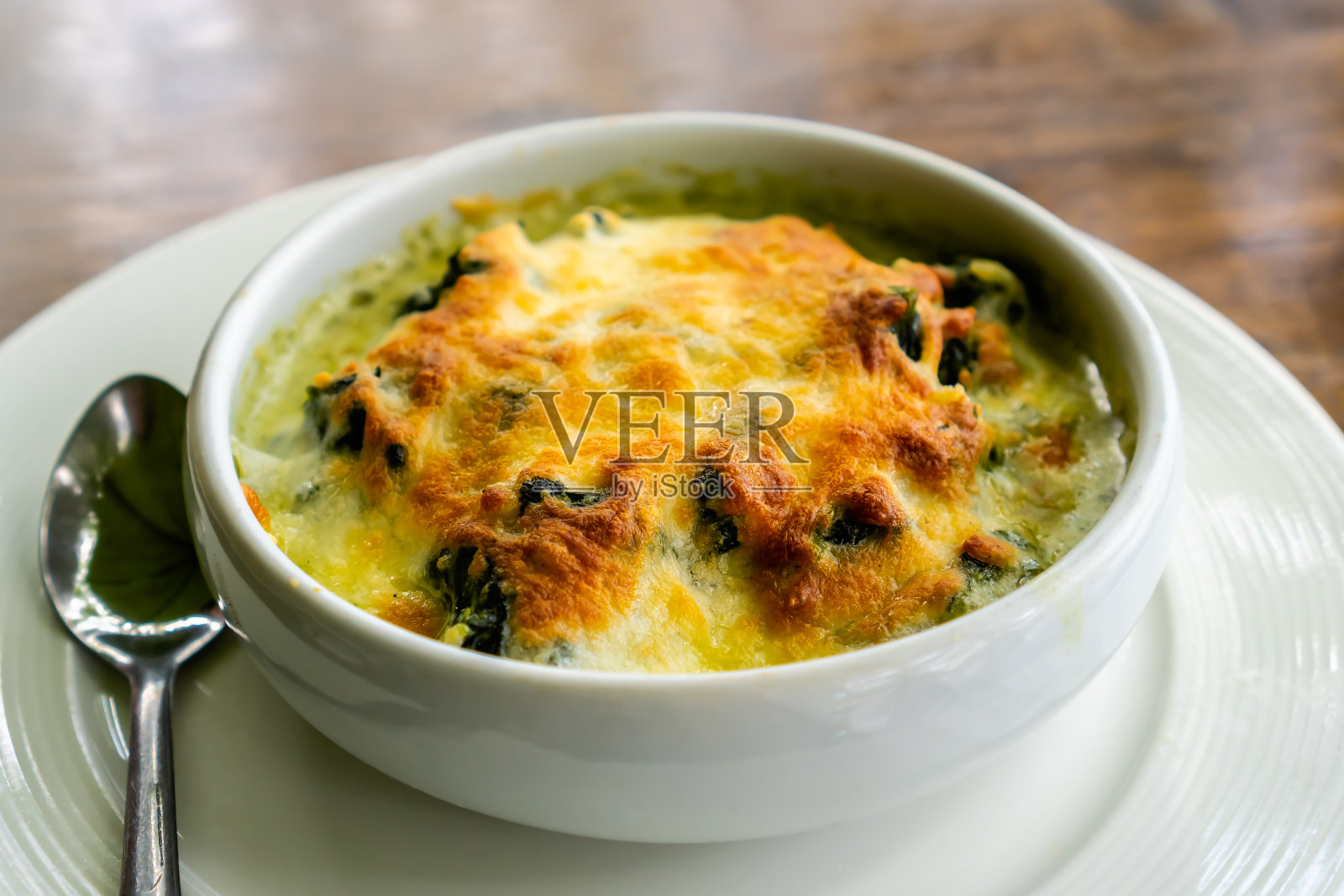 白碗焗菠菜配芝士。照片摄影图片