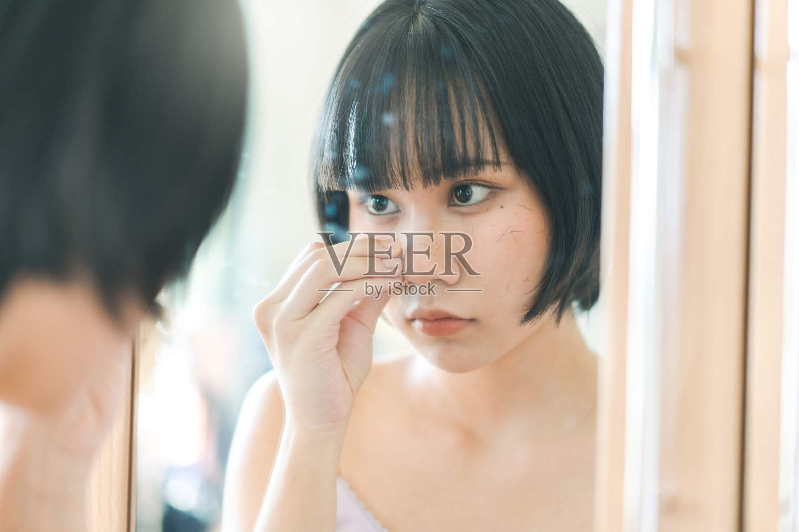 年轻的成年亚洲女性自己剪刘海的剪发在家里与自然的光。照片摄影图片