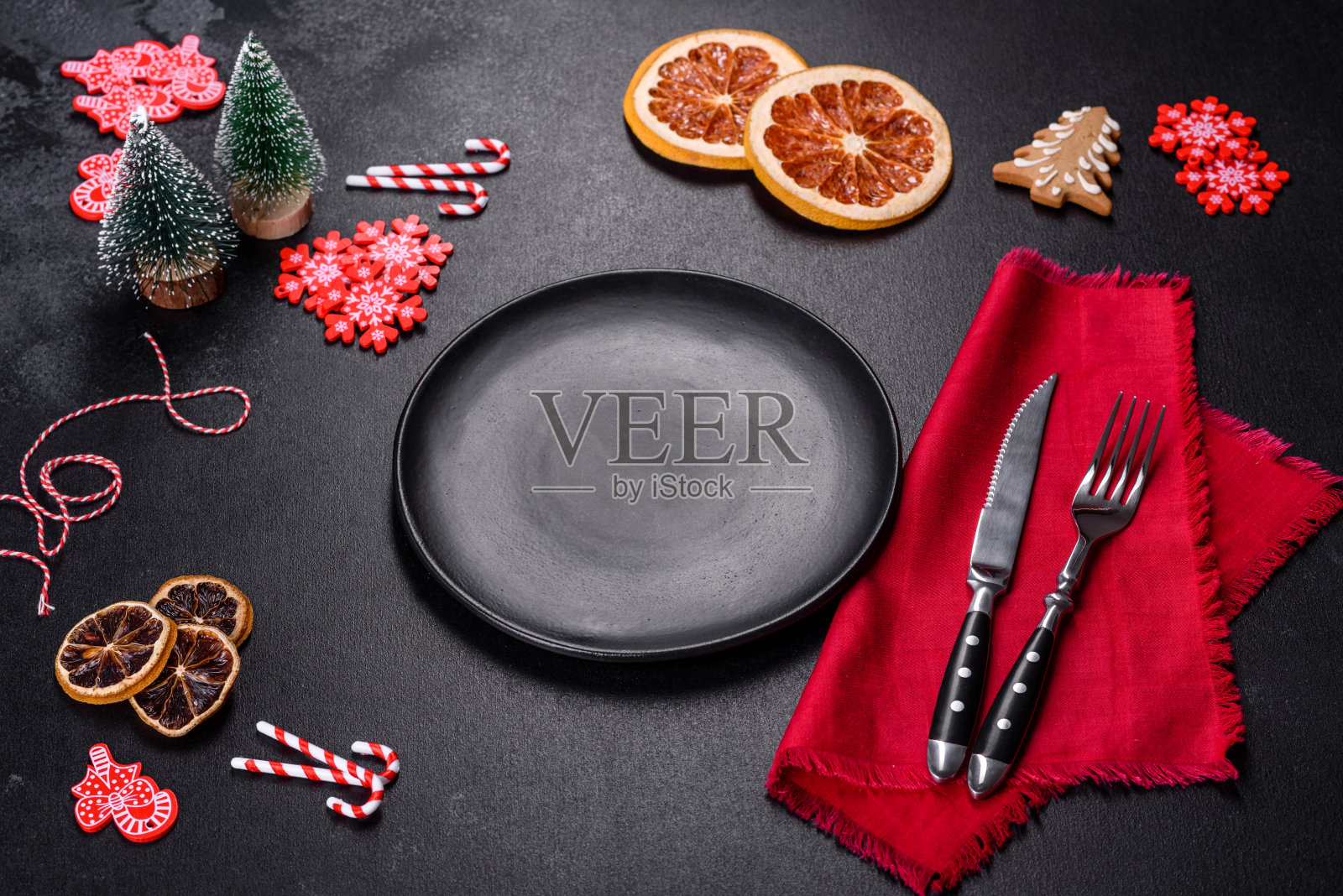 圣诞餐桌设置空黑色陶瓷板,冷杉树和黑色配件照片摄影图片