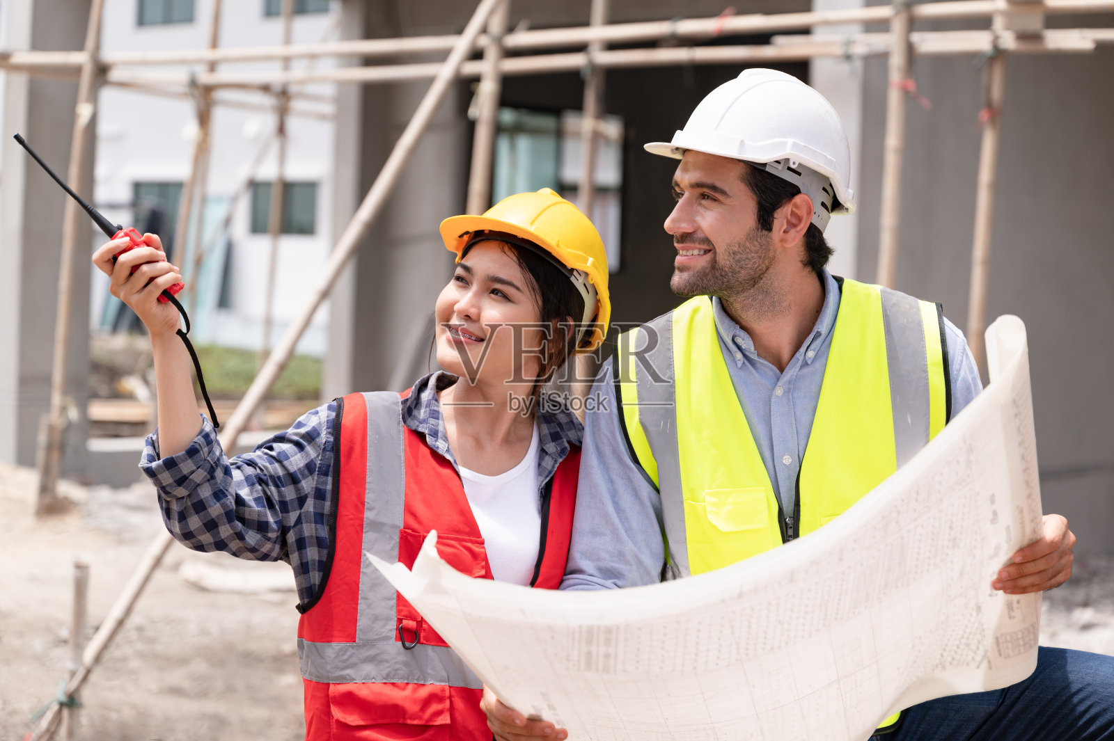 机械工程师团队在建筑工地进行书面工作照片摄影图片