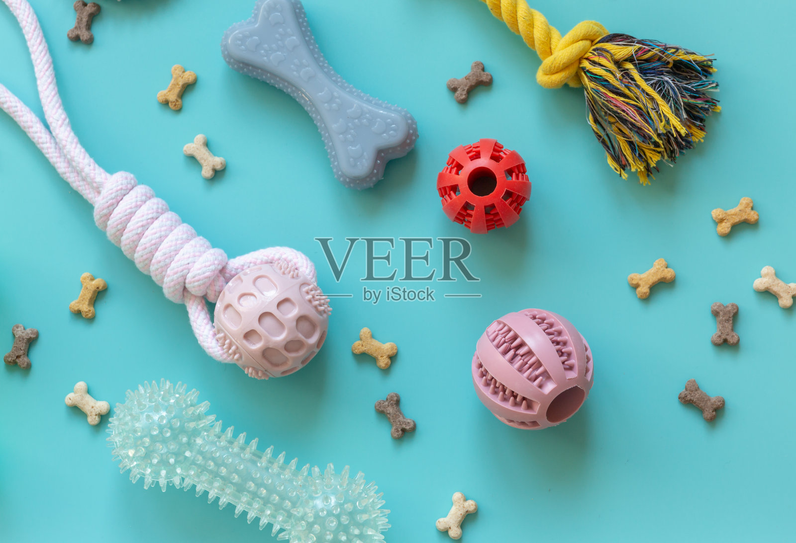 特写橡皮球,宠物圈。五颜六色的狗球和蓝色背景的骨头零食。玩具,球,骨头,用于玩耍和训练照片摄影图片