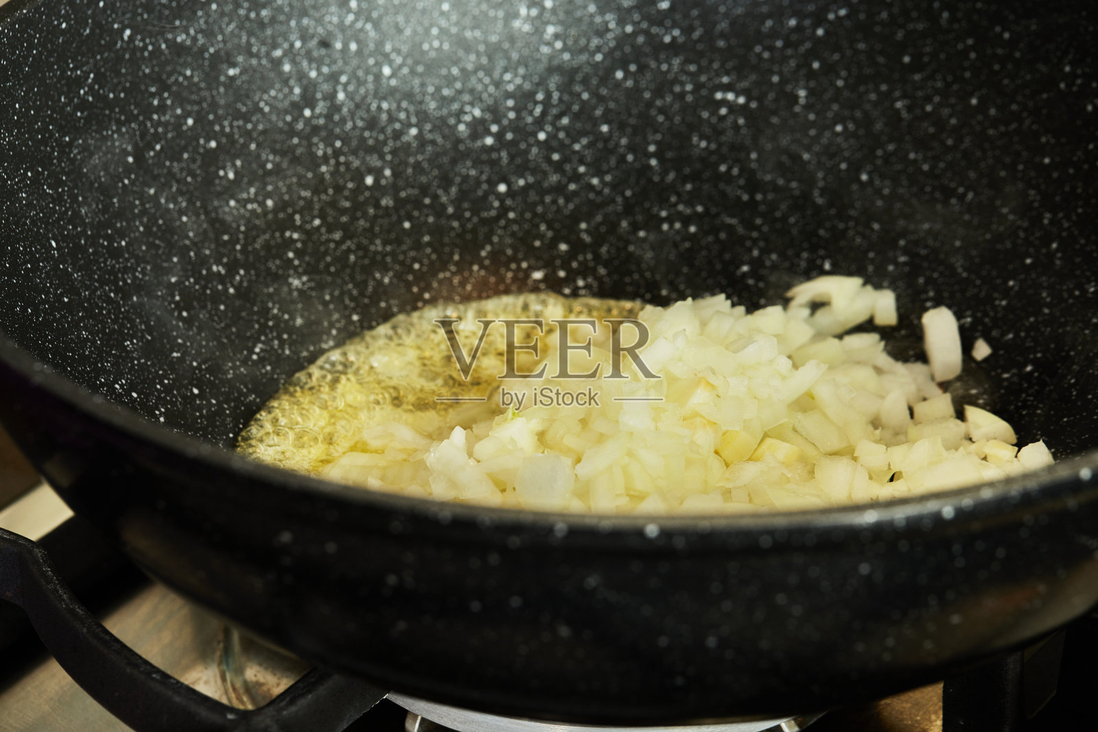 燃气灶上用油煎炸精细切碎的洋葱照片摄影图片