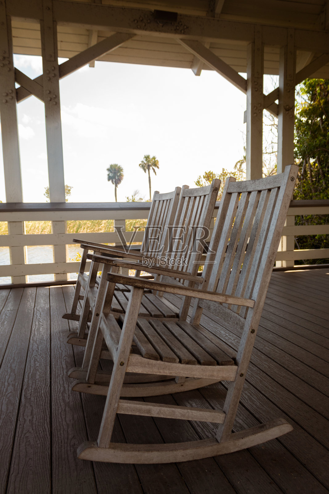 一个小木屋里的三个木制摇椅的垂直镜头照片摄影图片