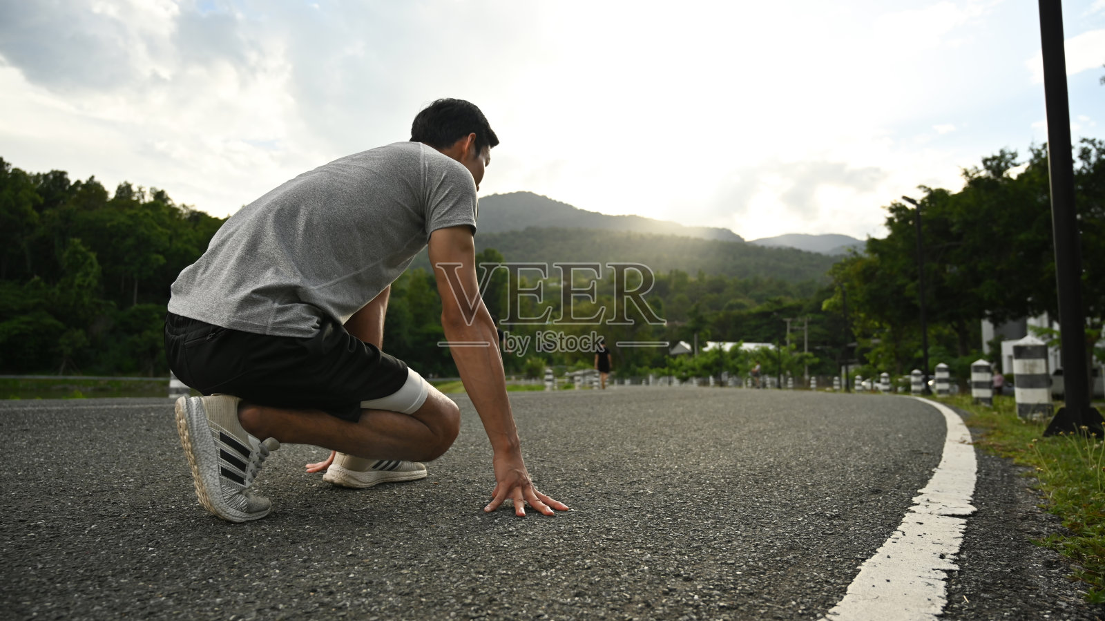 年轻的运动员站在起跑线上,准备早上在户外跑步。拼搏求胜,健康运动理念。照片摄影图片