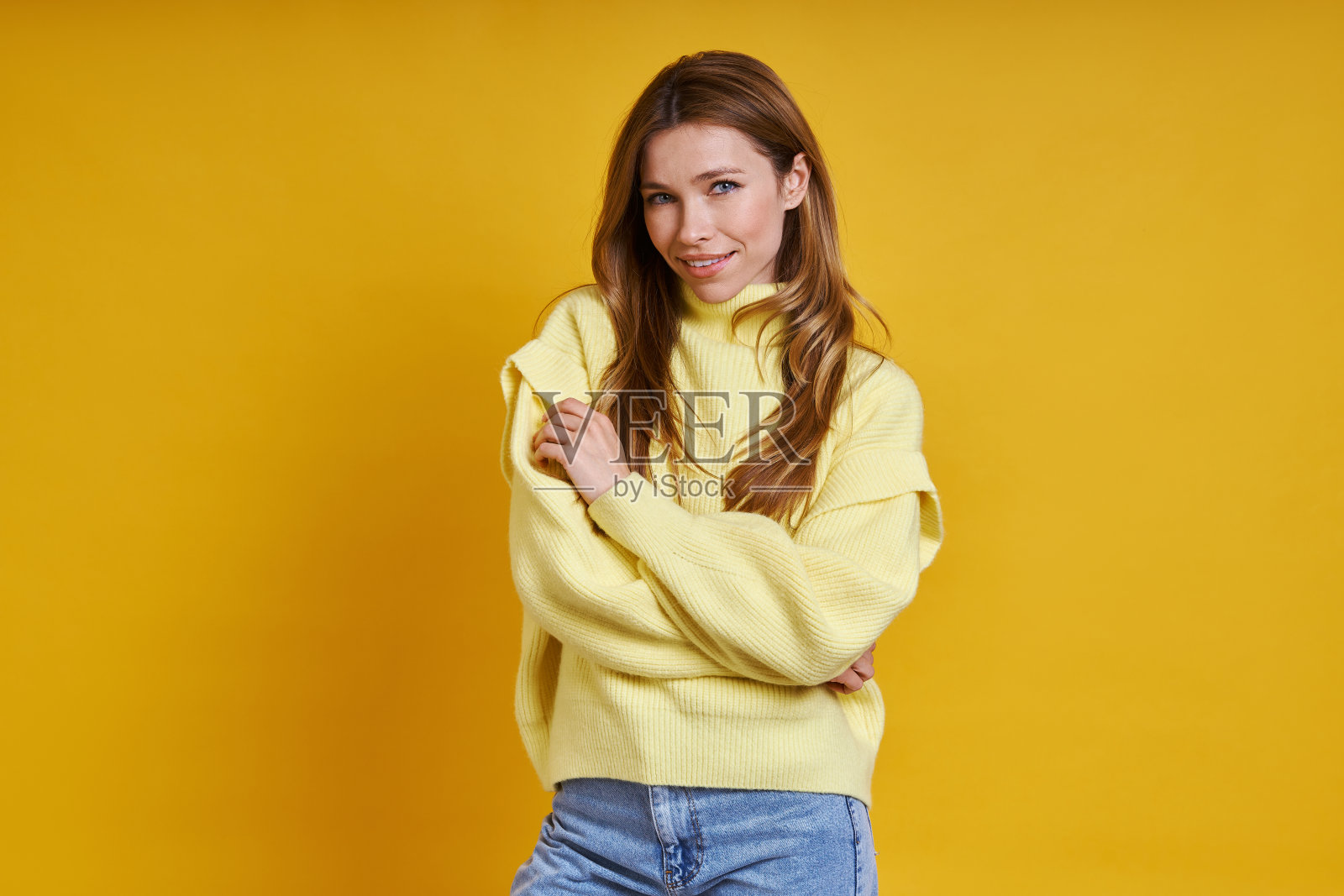 美丽的年轻女人在舒适的毛衣拥抱自己照片摄影图片