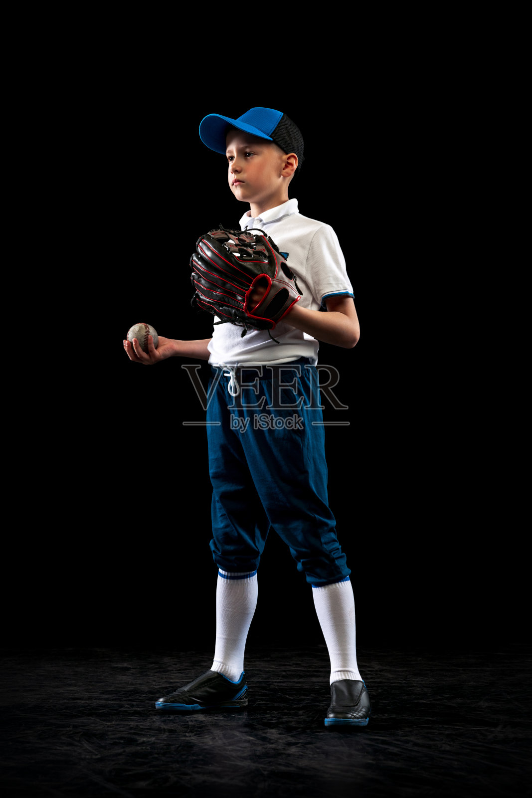 儿童肖像,初学者棒球运动员在运动制服与棒球手套隔离在黑暗的背景。体育的概念,成就,竞争照片摄影图片