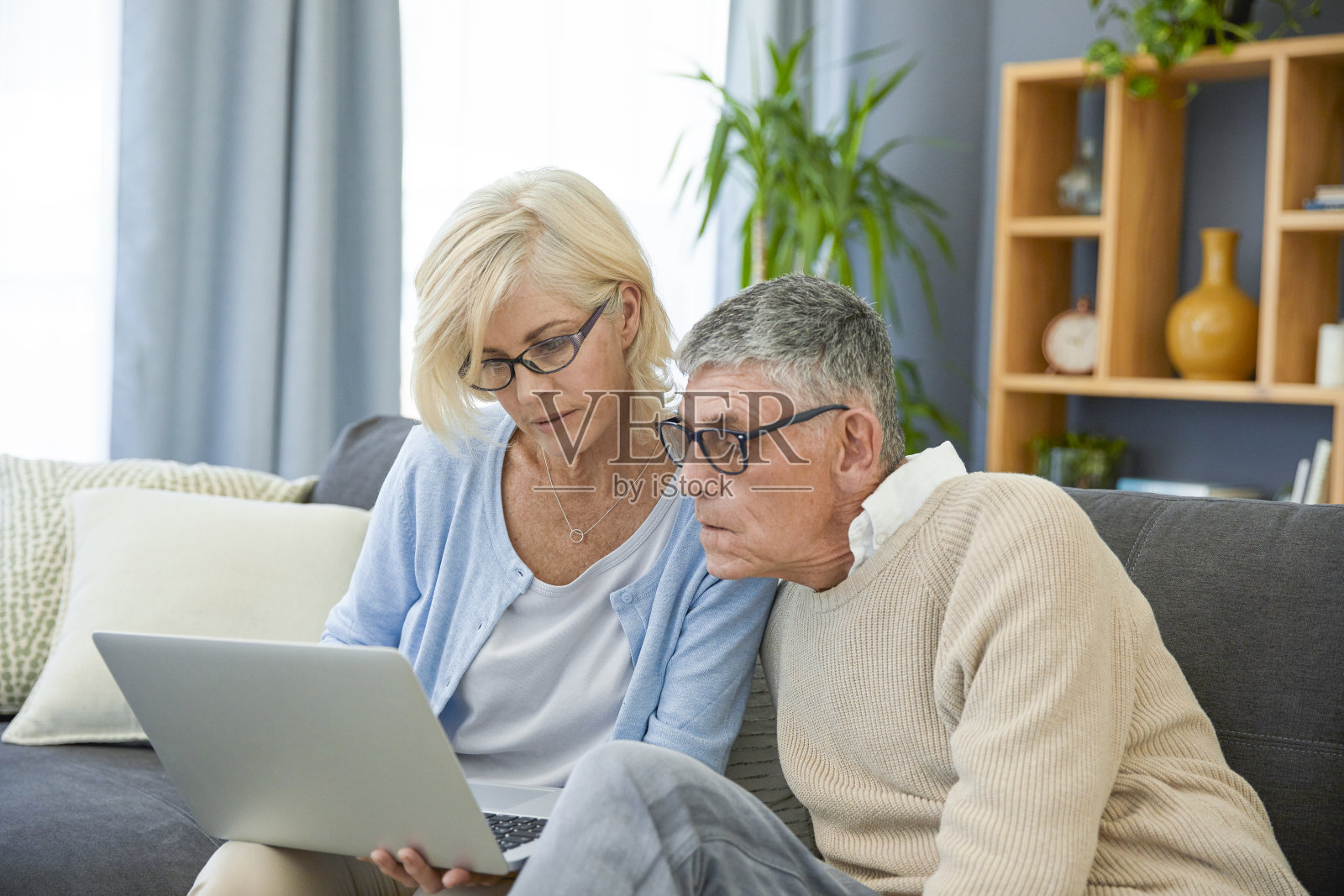 一对老夫妇坐在客厅里用笔记本电脑照片摄影图片