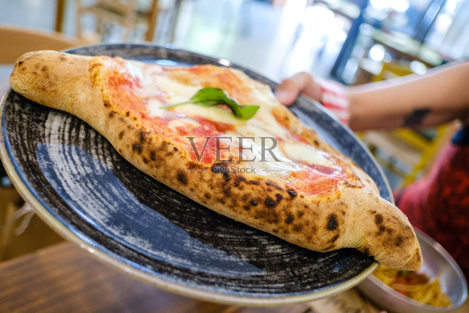 披萨,通常是意大利的,由女服务员端上来照片摄影图片