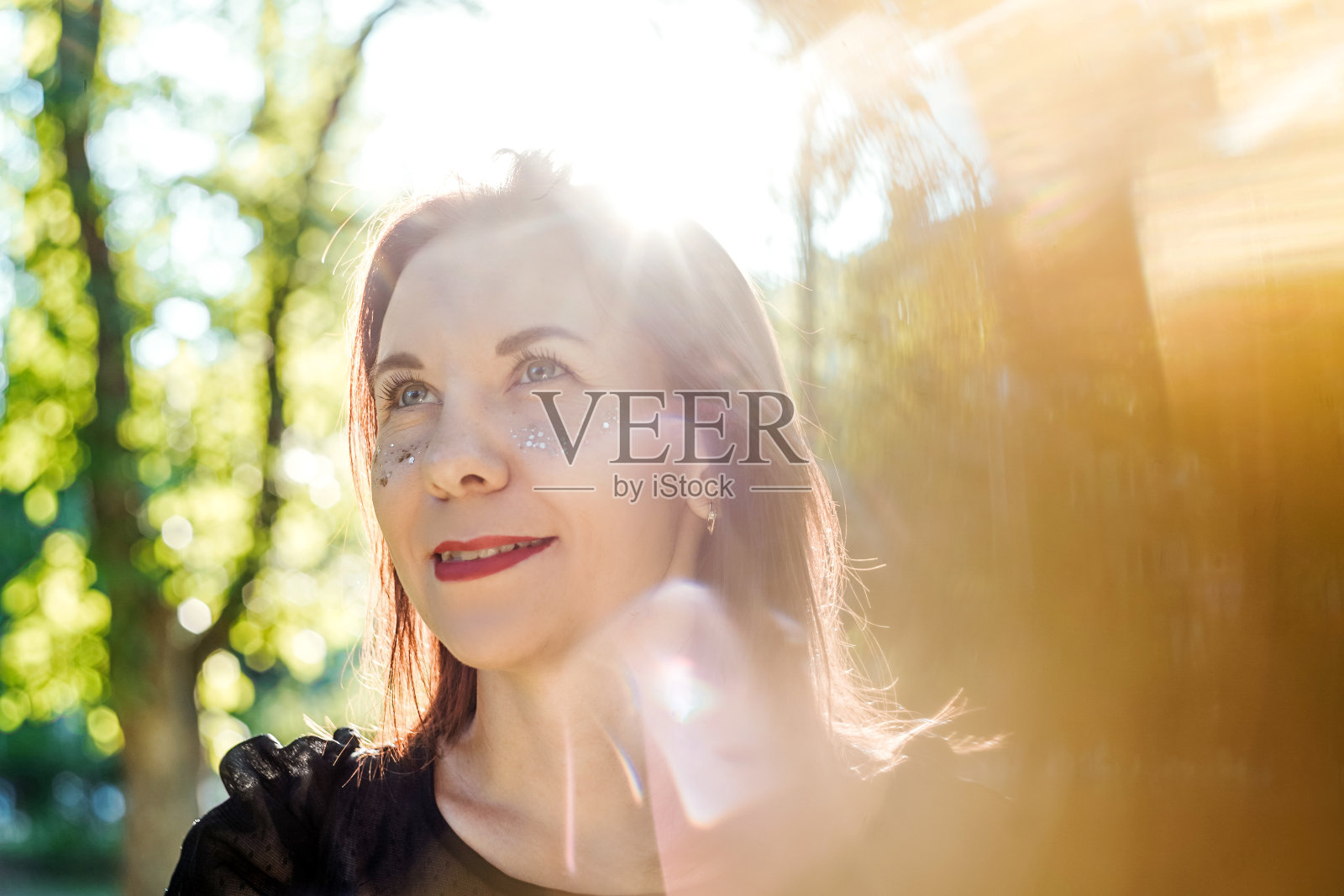 公园里一个满脸雀斑的年轻女人。照片摄影图片