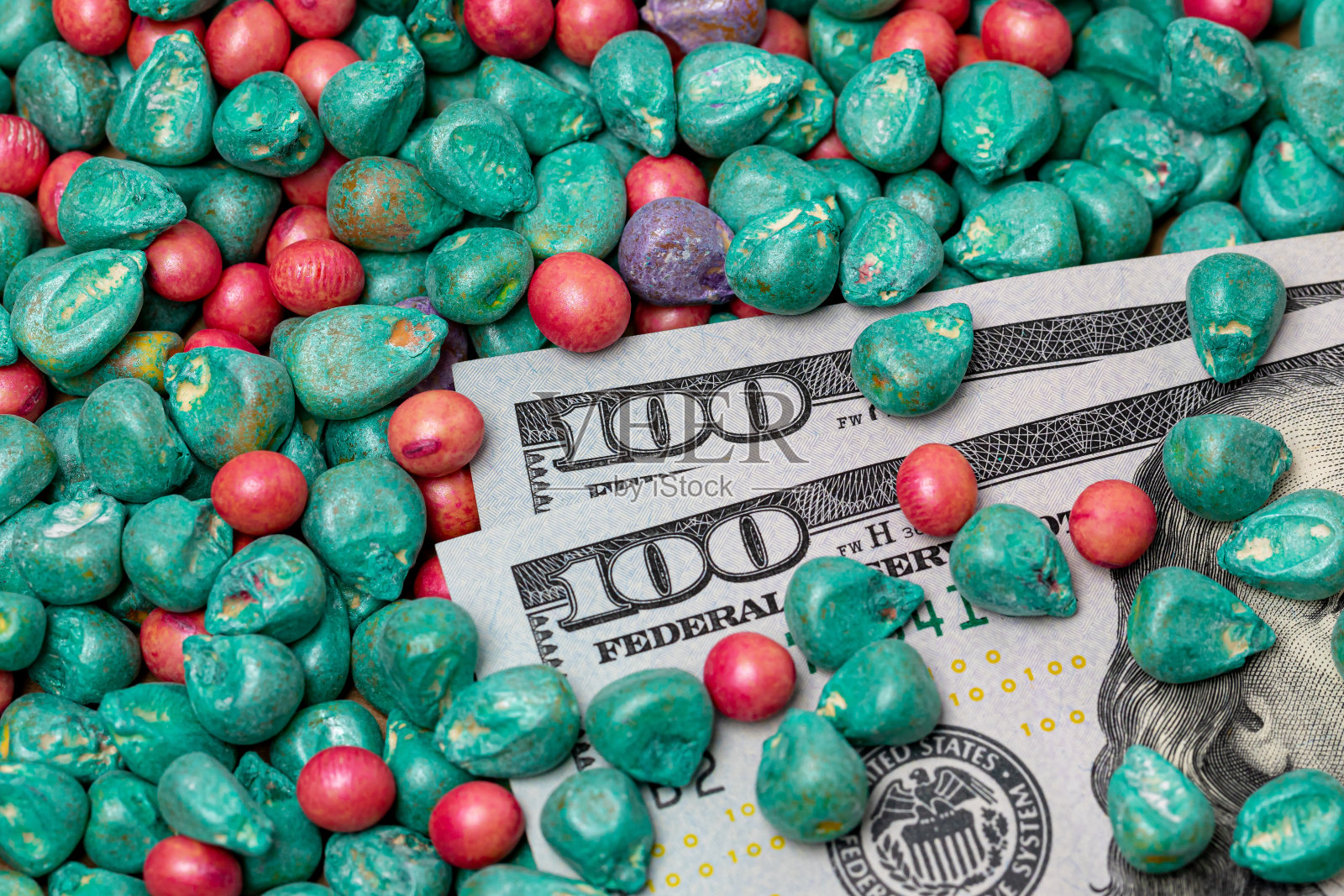 处理过的大豆和玉米种子和现金的特写。农业病虫害种子处理、真菌防治和病虫害管理理念照片摄影图片