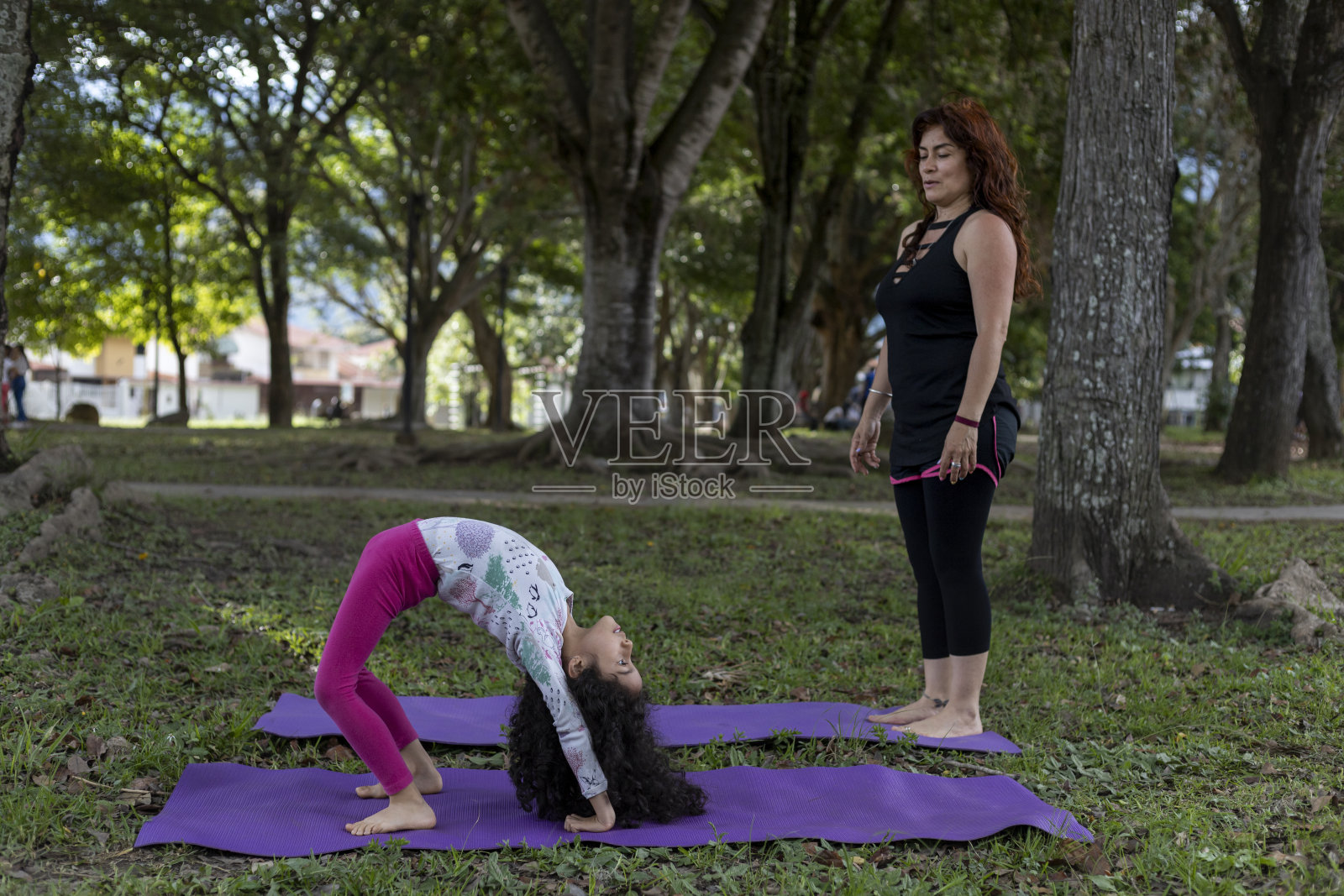 拉丁美洲的母女俩在公园里一起做瑜伽和锻炼,玩得很开心照片摄影图片