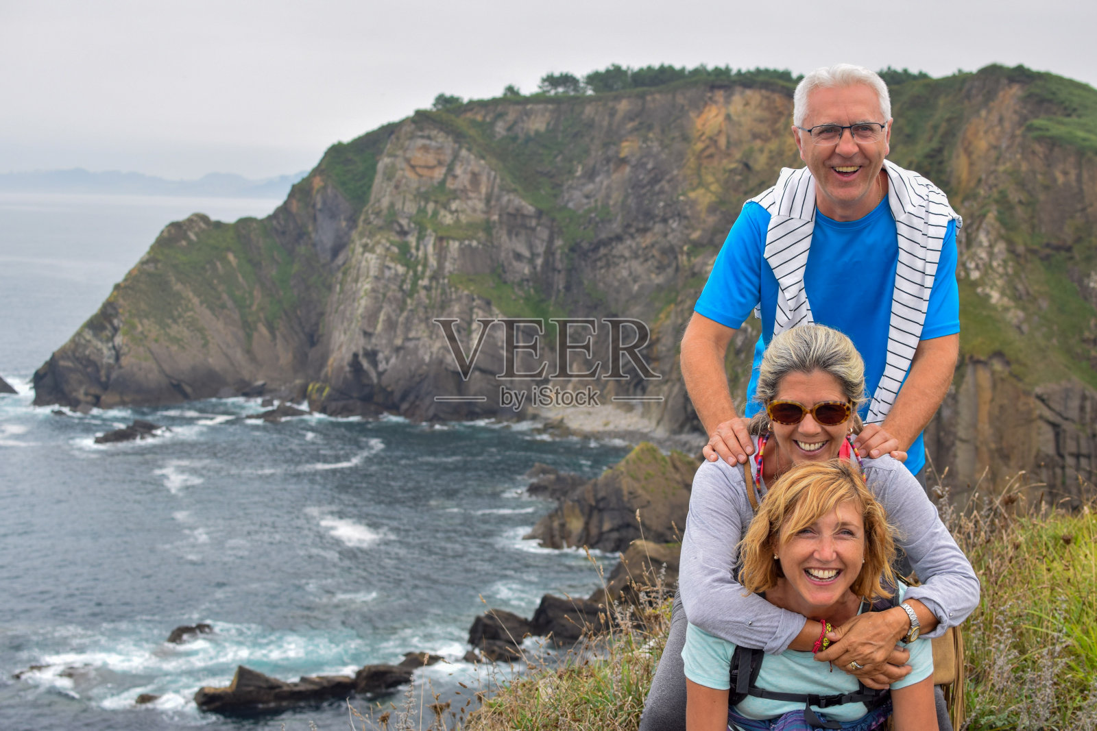 三个成熟的朋友在美丽的山海背景照片摄影图片