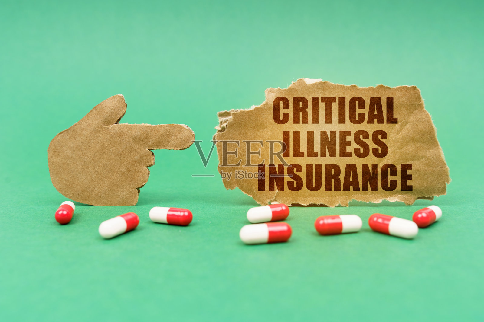 在绿色的匾额上,有一只手指着一个写着“大病保险”的牌子照片摄影图片