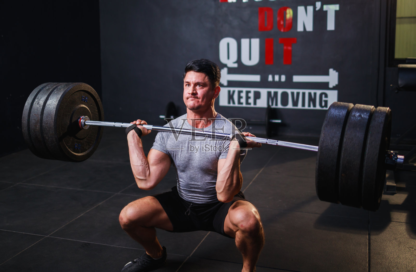 年轻的健美运动员在健身房做双肩杠铃运动照片摄影图片