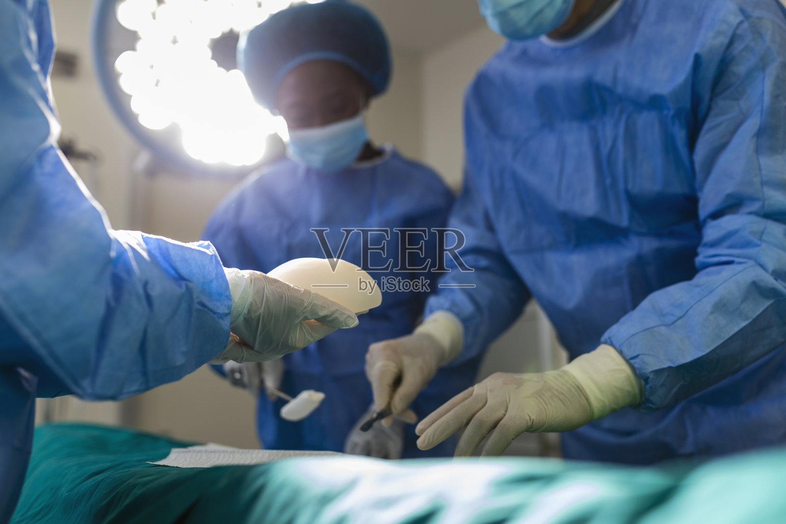 在心脏外科诊所,身穿制服的外科医生正在为病人做手术。现代医学,专业的外科医生队伍,健康。照片摄影图片