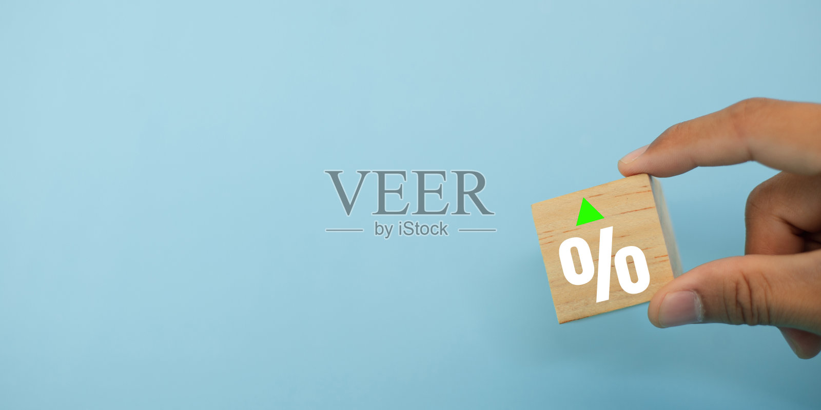 金融危机的概念。手握木块标志,蓝色背景上用百分比符号表示收入增长、资金损失、成本降低、下降的图表。利润下降。照片摄影图片