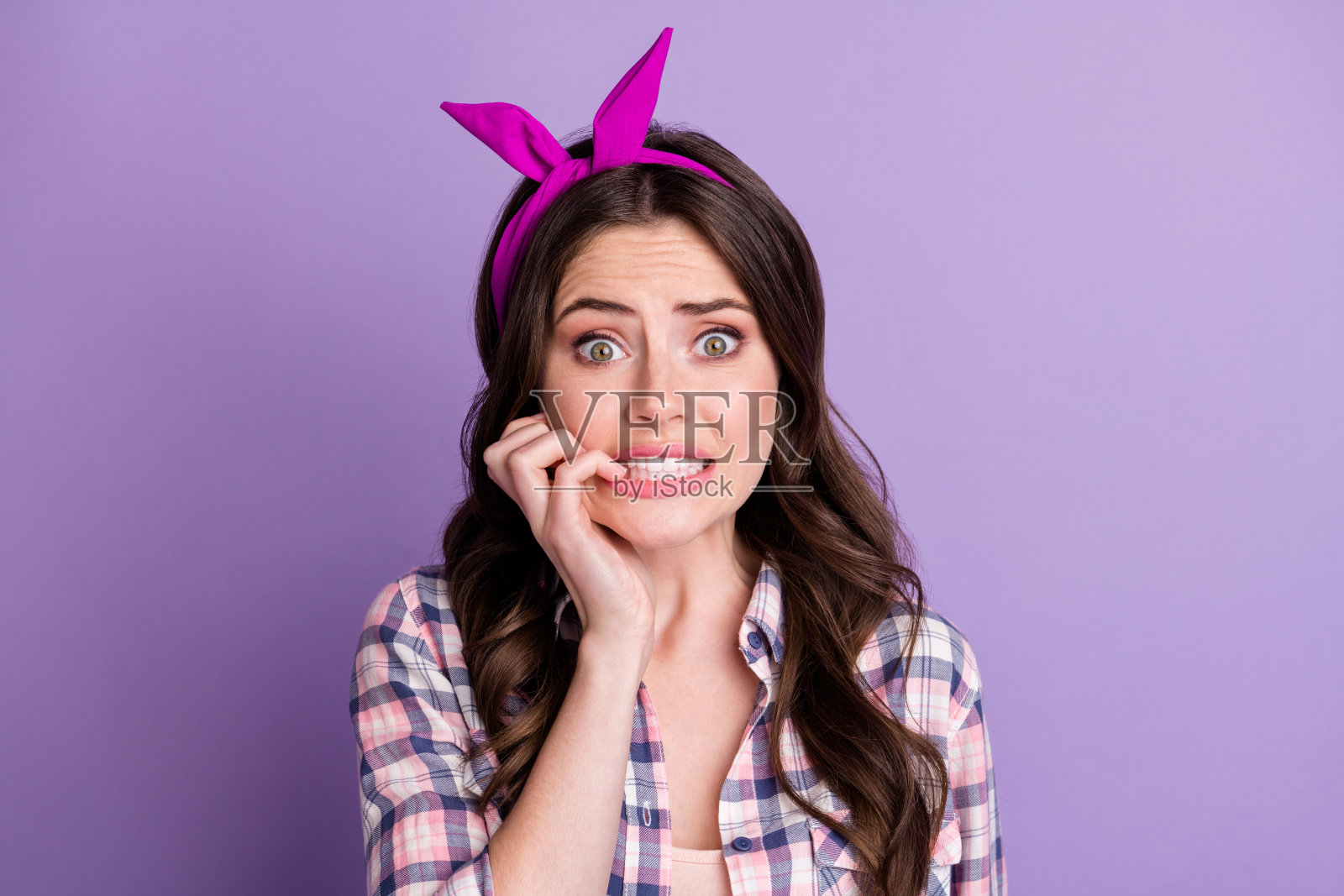 照片肖像的害怕的女人咬指甲孤立在生动的紫色背景照片摄影图片