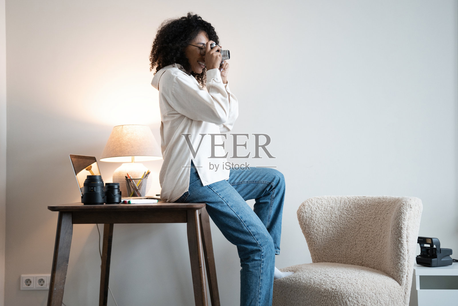 年轻的混合种族女性摄影师与专业相机在办公室照片摄影图片