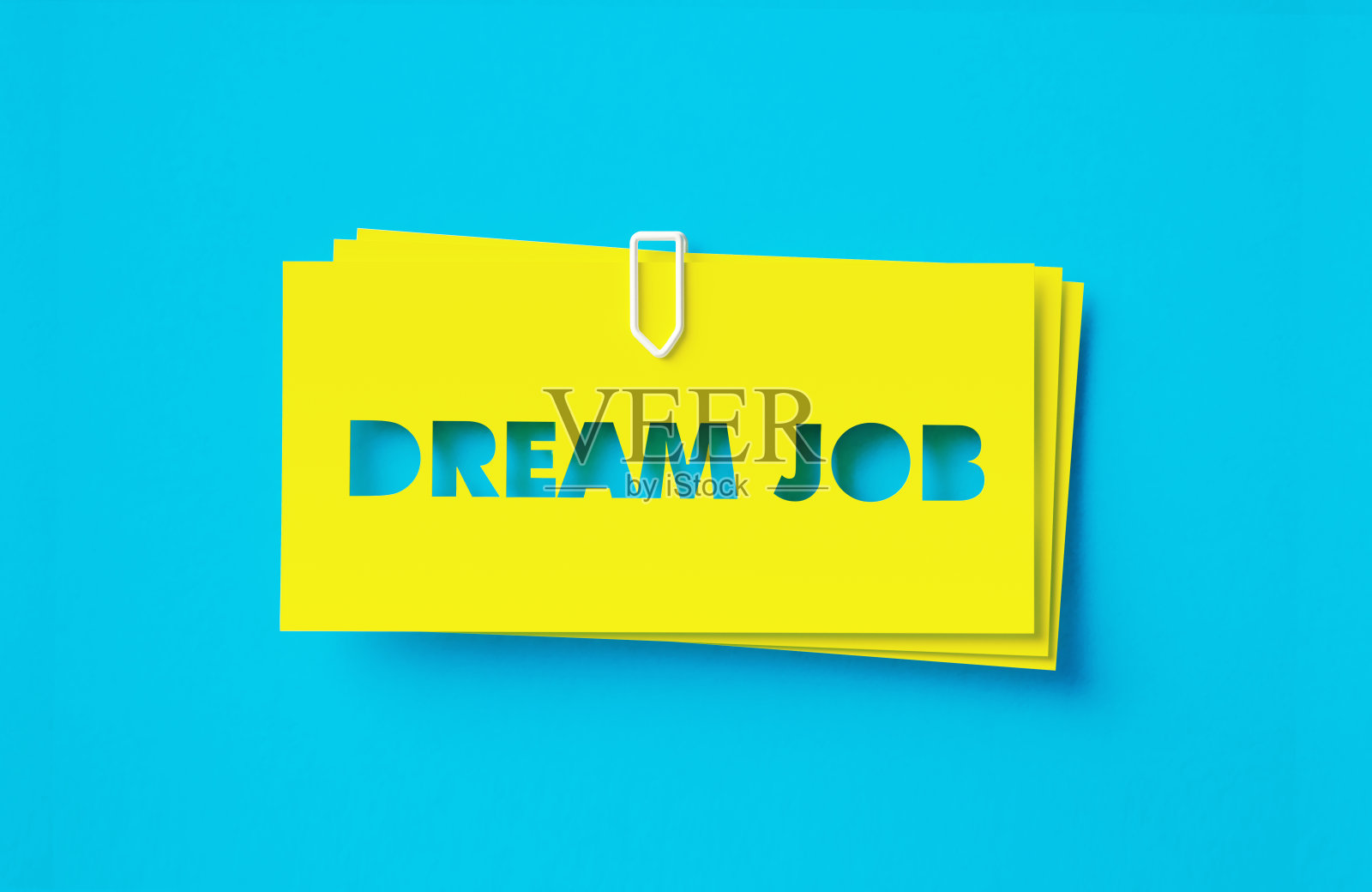 在绿松石色的背景上剪下黄色的不干胶照片摄影图片