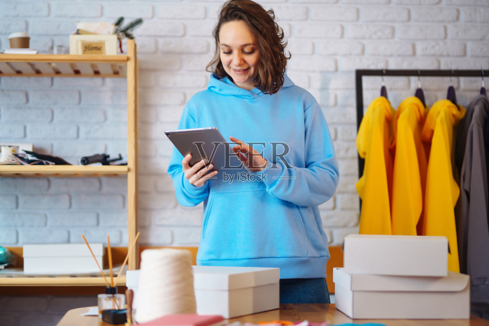 小企业主,企业家,卖家手里拿着平板电脑分析销售,发送新订单和查看股票。照片摄影图片