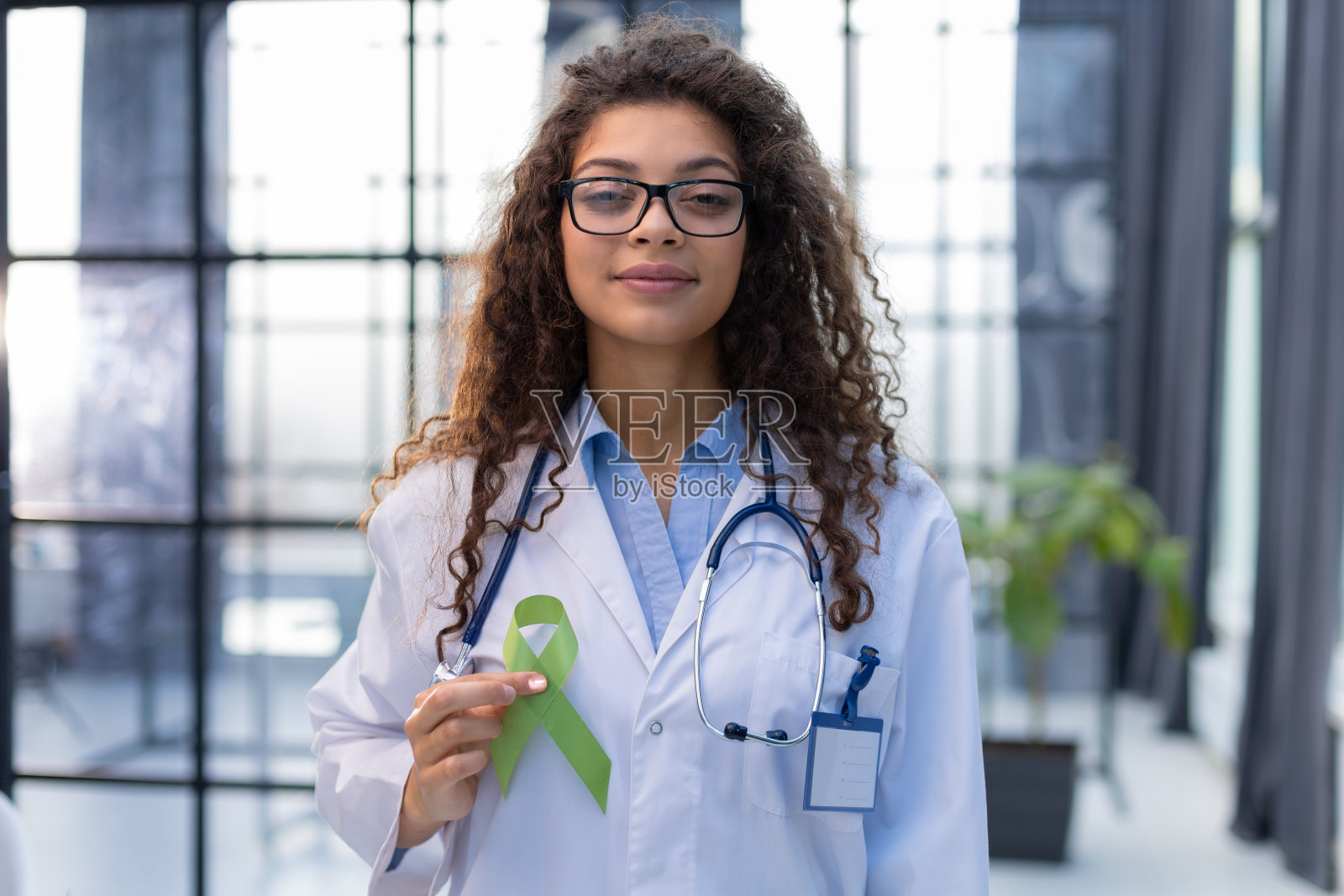 医生手中的绿丝带象征着对淋巴瘤的认识照片摄影图片