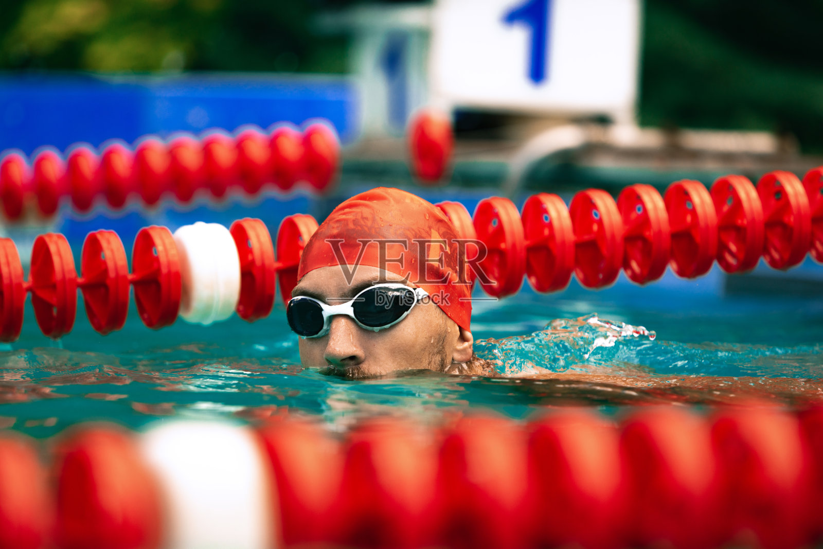 在游泳池。英俊的男子,戴着游泳帽和泳镜在公共游泳池训练。度假,积极的生活方式,动力,能量,运动照片摄影图片