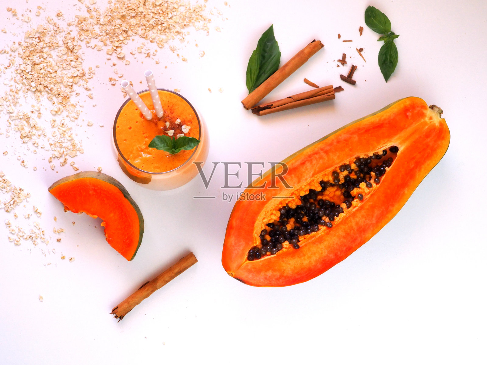 木瓜燕麦奶昔,新鲜木瓜,肉桂棒。平的。照片摄影图片