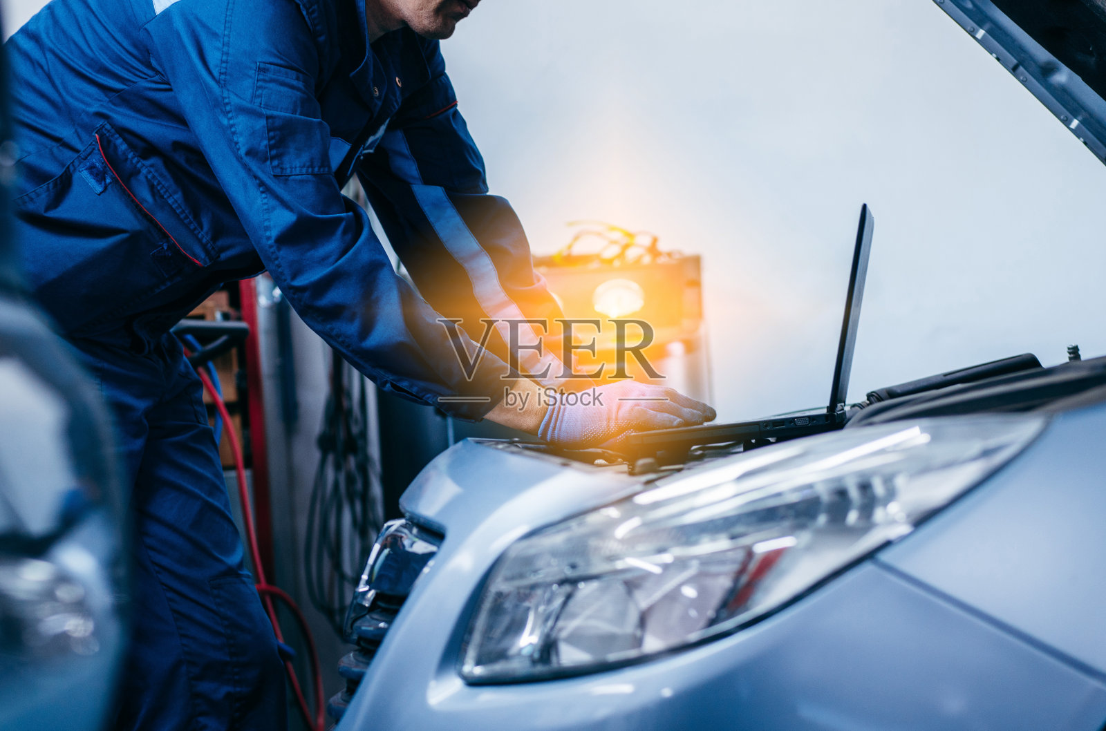 近距离观察汽车电工使用笔记本电脑诊断和检查汽车发动机部件进行修理和修理的手照片摄影图片