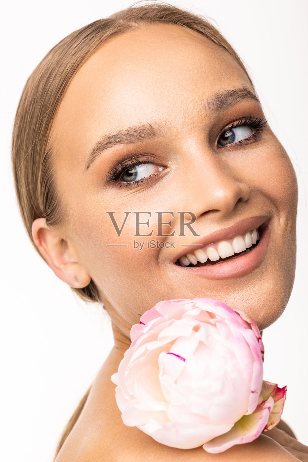 年轻美丽的女子放松与莲花水疗隔离在白色的背景,专业的美妆照片摄影图片