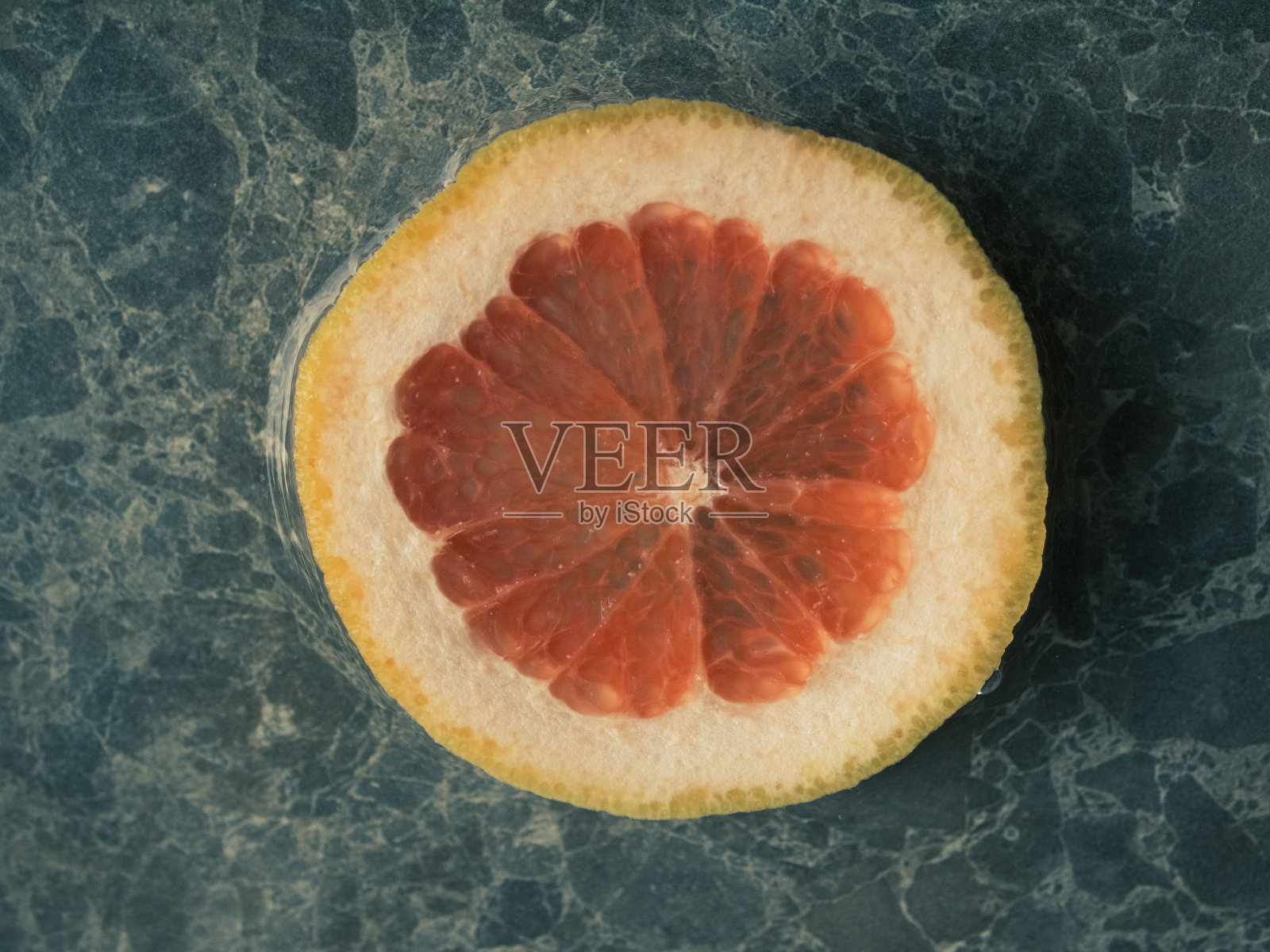 石头背景上的一片红柚子。平的概念。照片摄影图片