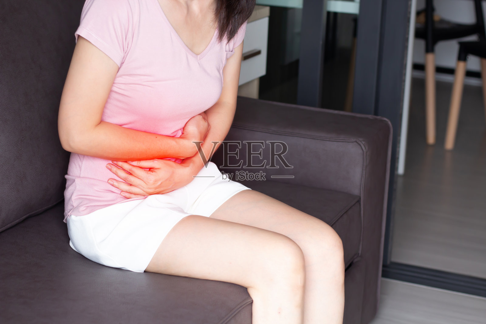 亚洲女性胃疼,用手交叉胃,感觉疼痛和发炎照片摄影图片