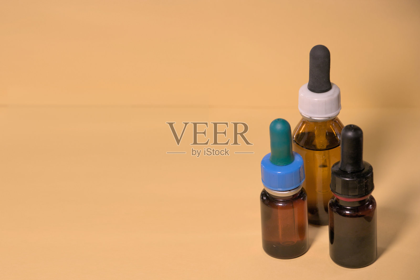 带滴管的棕色瓶子,没有商标,文字空间,淡黄色背景。照片摄影图片