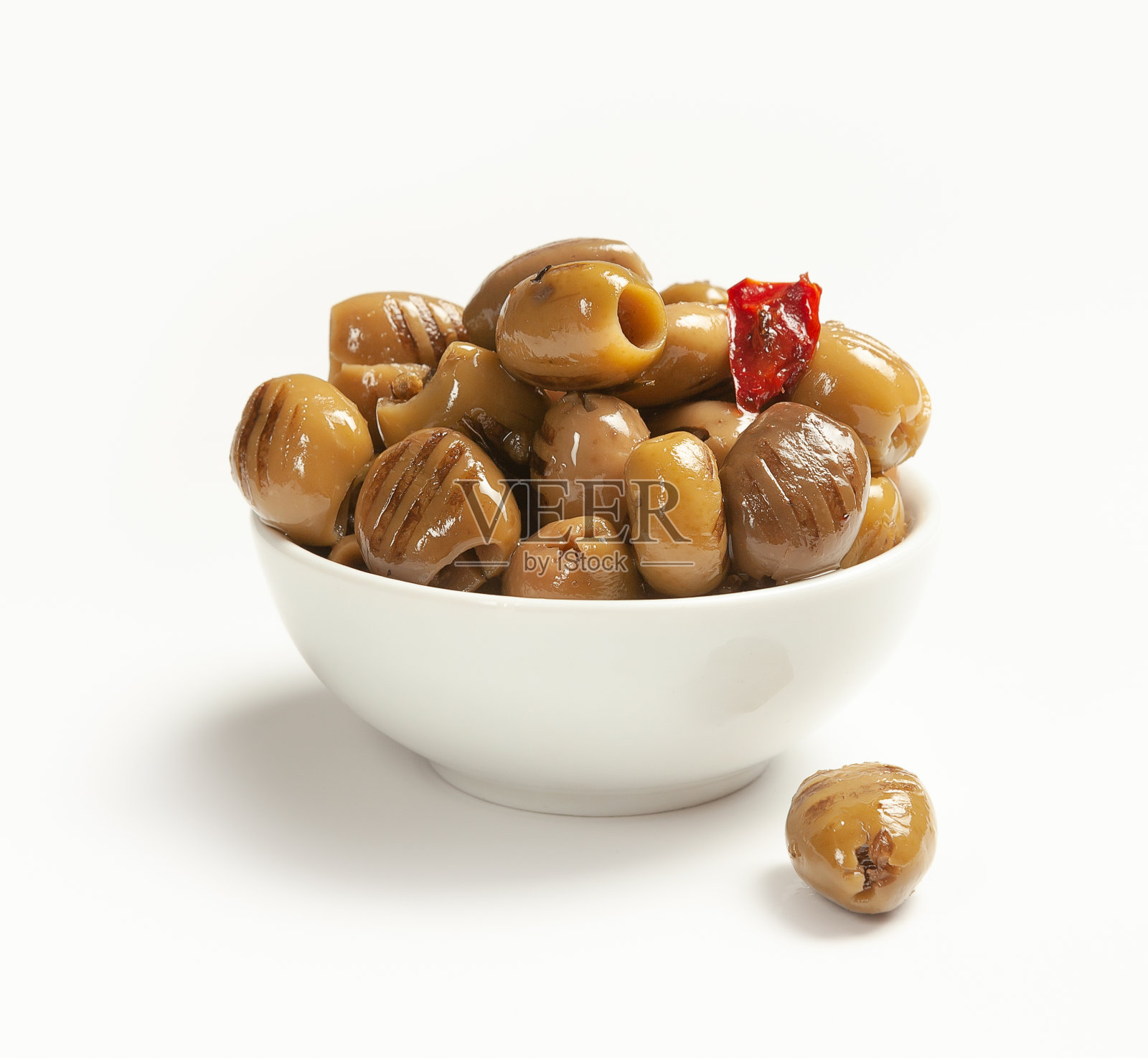 油煎绿橄榄,白碗里放红辣椒和大蒜照片摄影图片