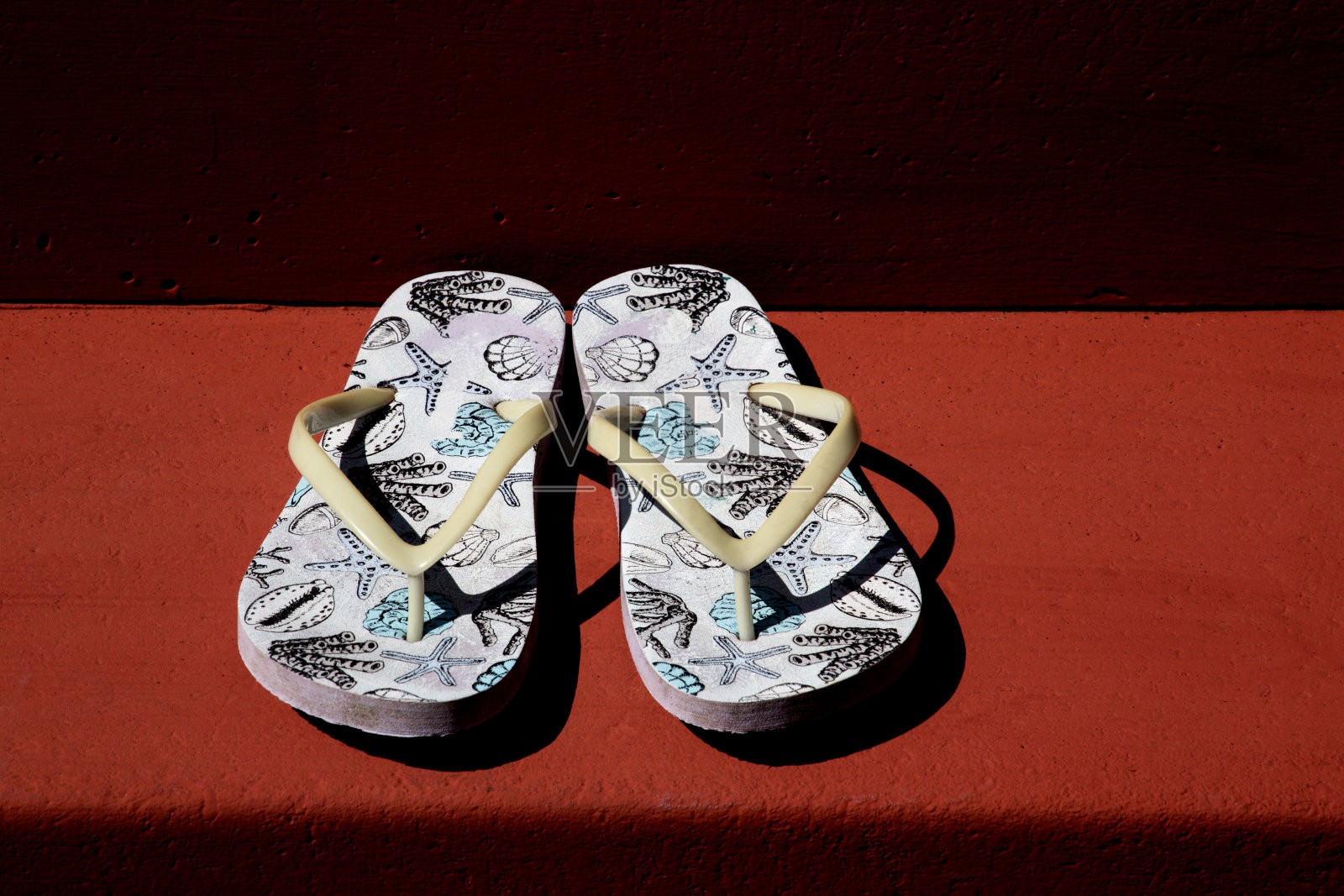 红色油漆混凝土台阶上的旧拖鞋照片摄影图片