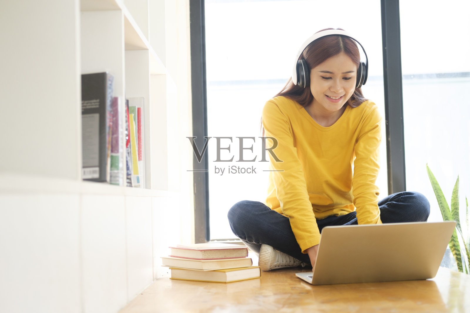 利用电脑和移动设备在线学习的年轻大学生。照片摄影图片