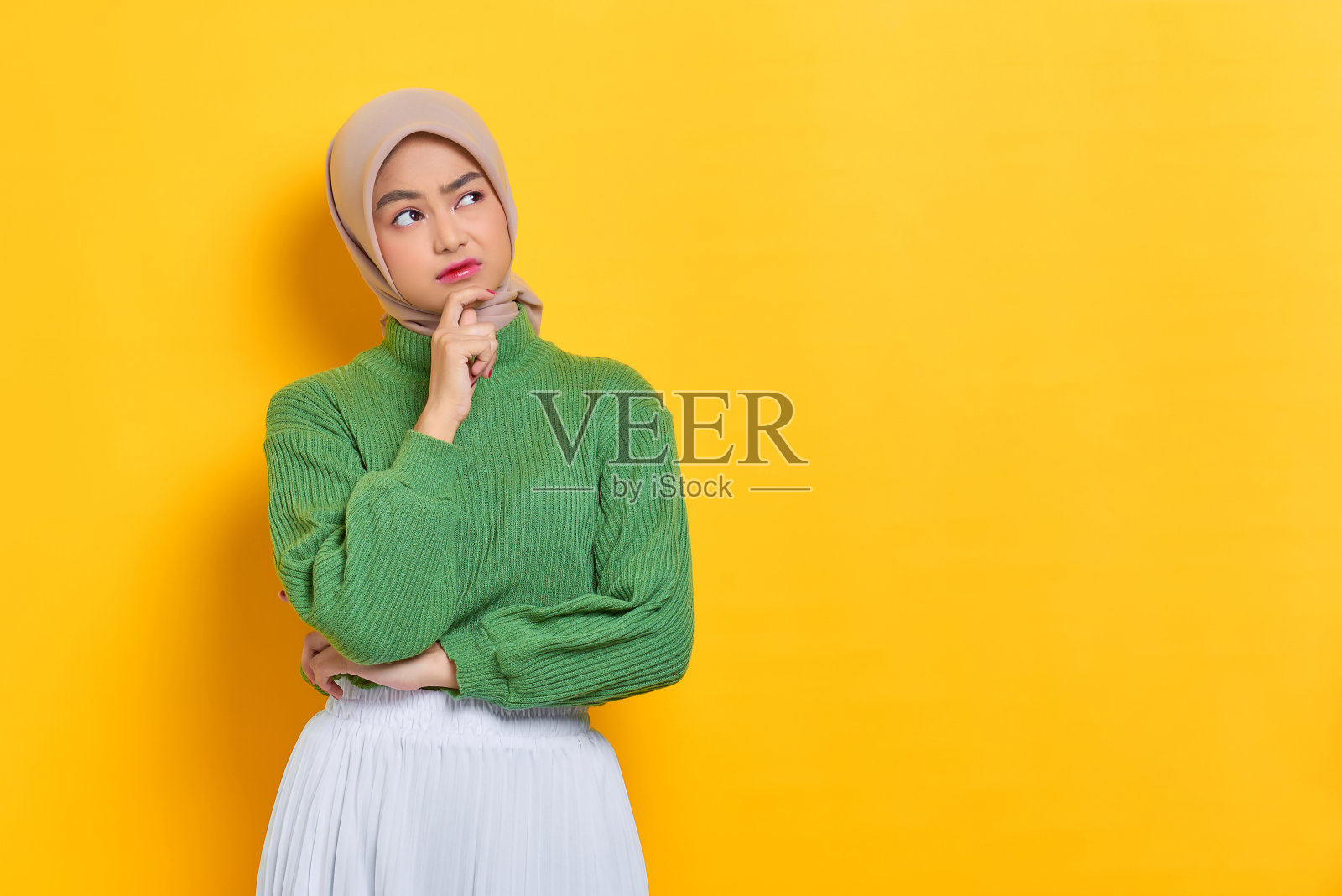 沉思美丽的亚洲女人在绿色毛衣思考的东西和看远离孤立的白色背景照片摄影图片
