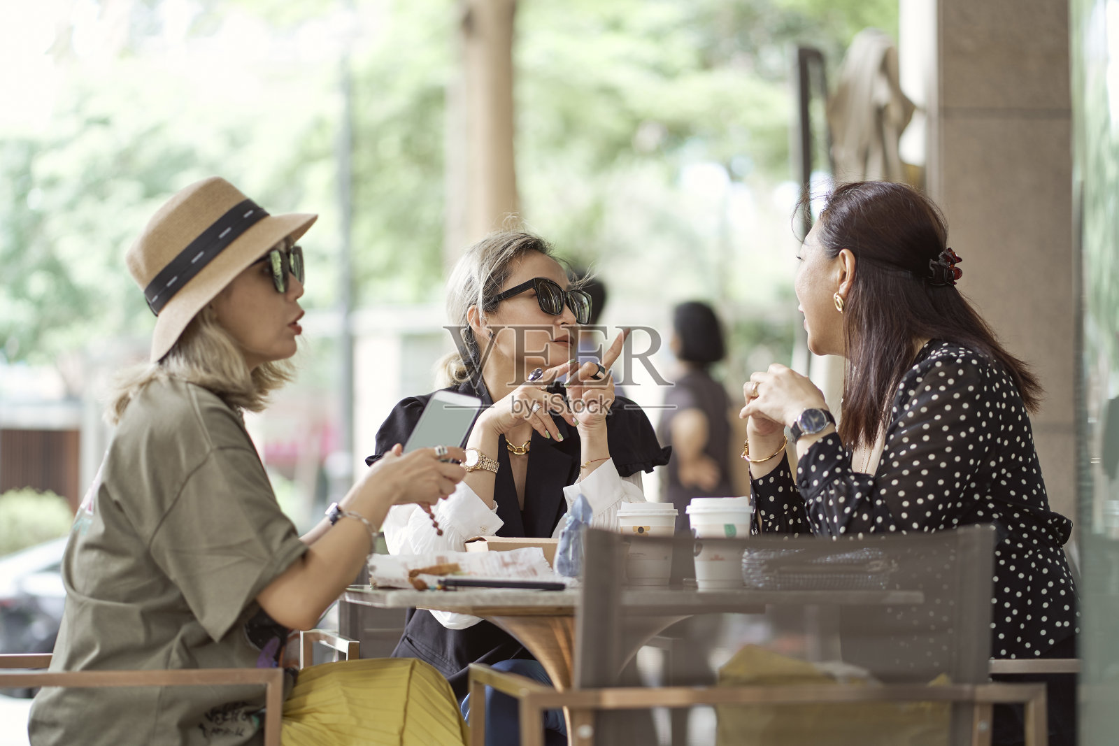 三个亚洲女人坐在咖啡店外聊天照片摄影图片