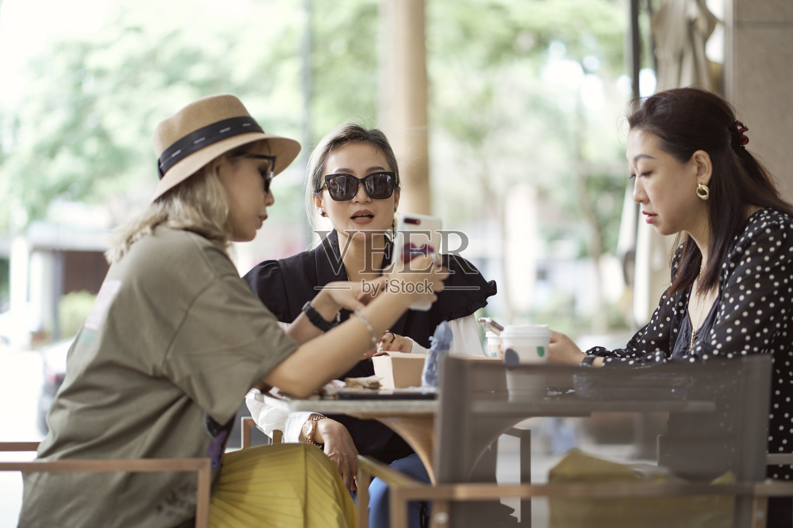 三个亚洲女人坐在咖啡店外聊天照片摄影图片