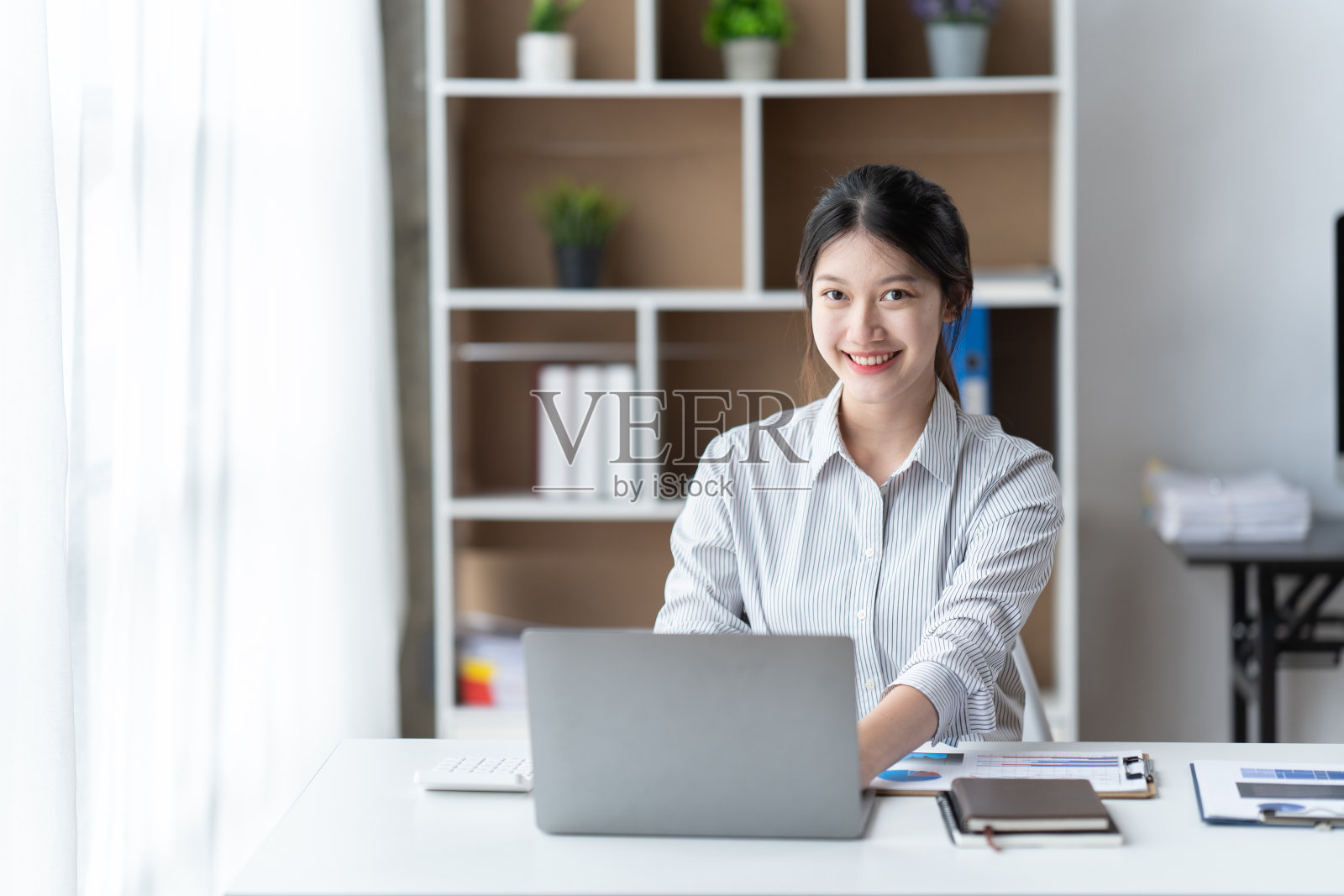 一位在办公室用笔记本电脑工作的亚洲女性。商业金融的概念。照片摄影图片
