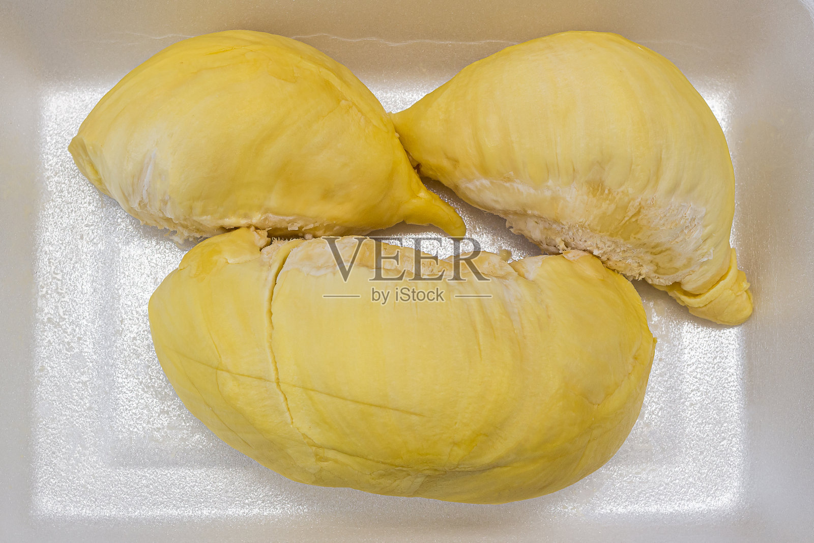 市场上,成熟的榴莲放在塑料托盘上。泰国的水果照片摄影图片