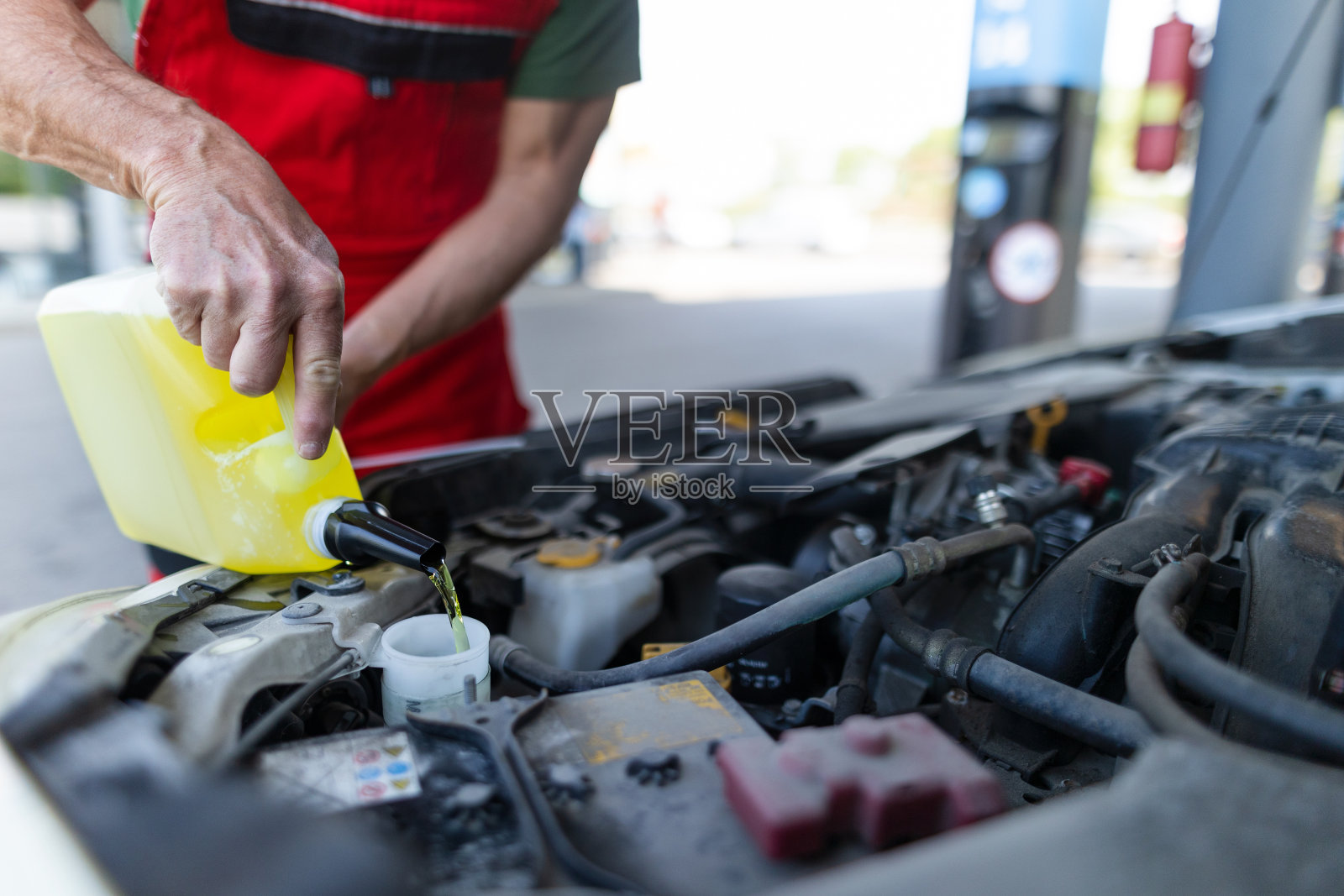汽车技师在维修服务站为发动机更换和加油照片摄影图片
