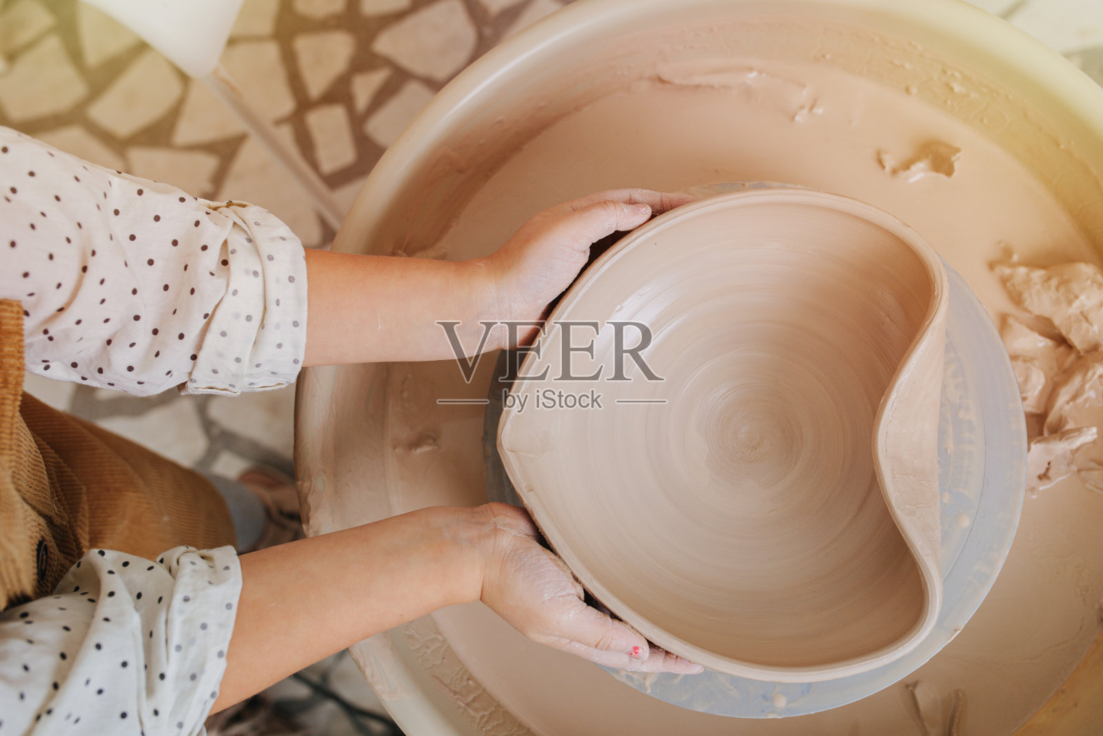 孩子的手把一个软陶碗塑造成心形。照片摄影图片