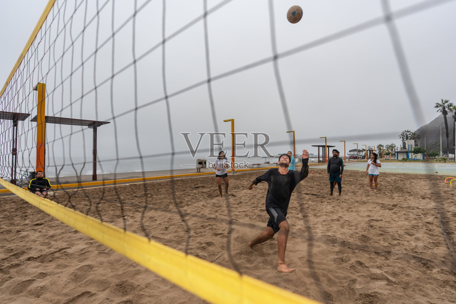 在沙滩上的一场集训比赛中,橄榄球队的队员照片摄影图片