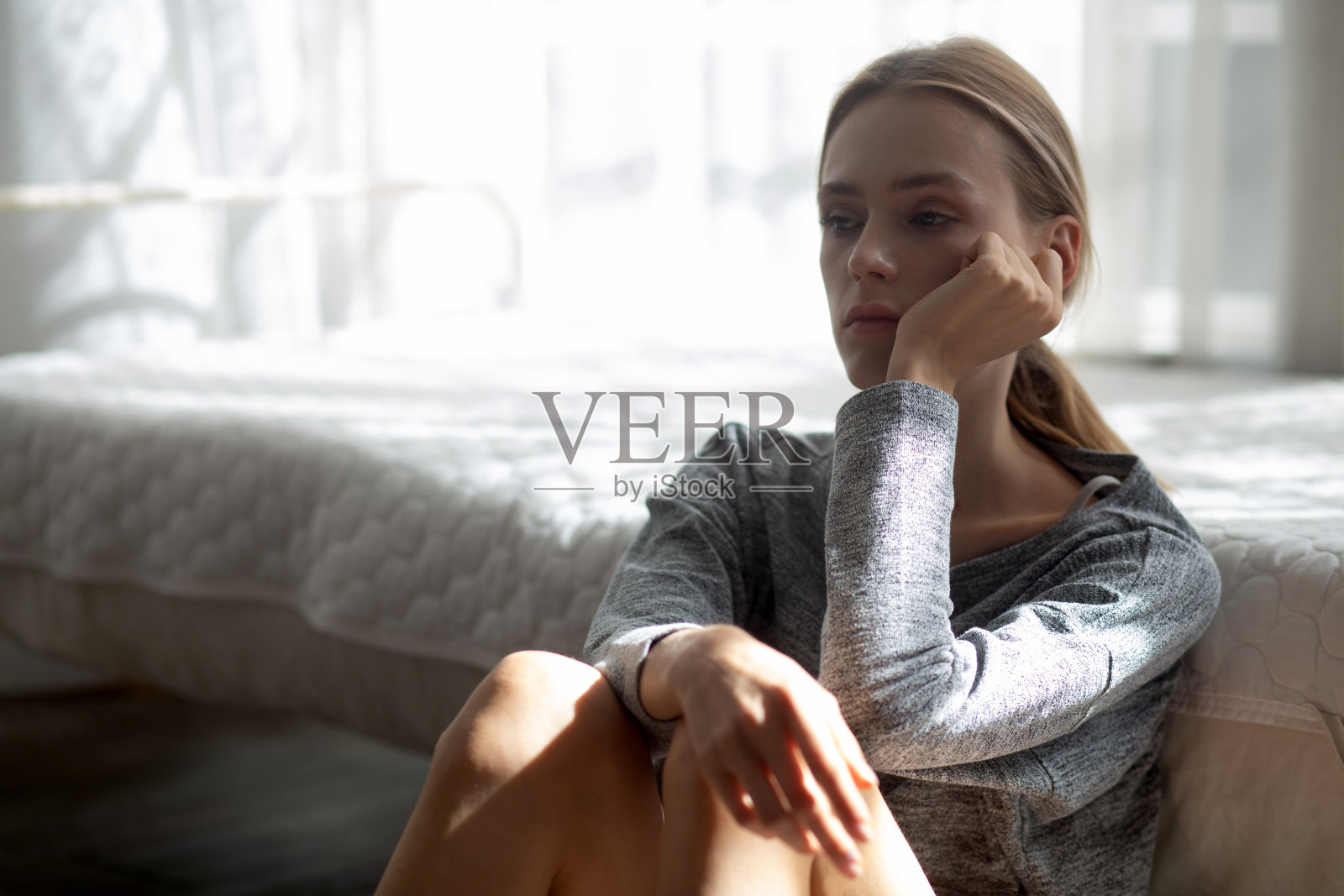 在卧室里有抑郁症和精神问题的年轻白人女性,情绪消极,女人孤独,担心,失望,表情和绝望,生活方式概念照片摄影图片