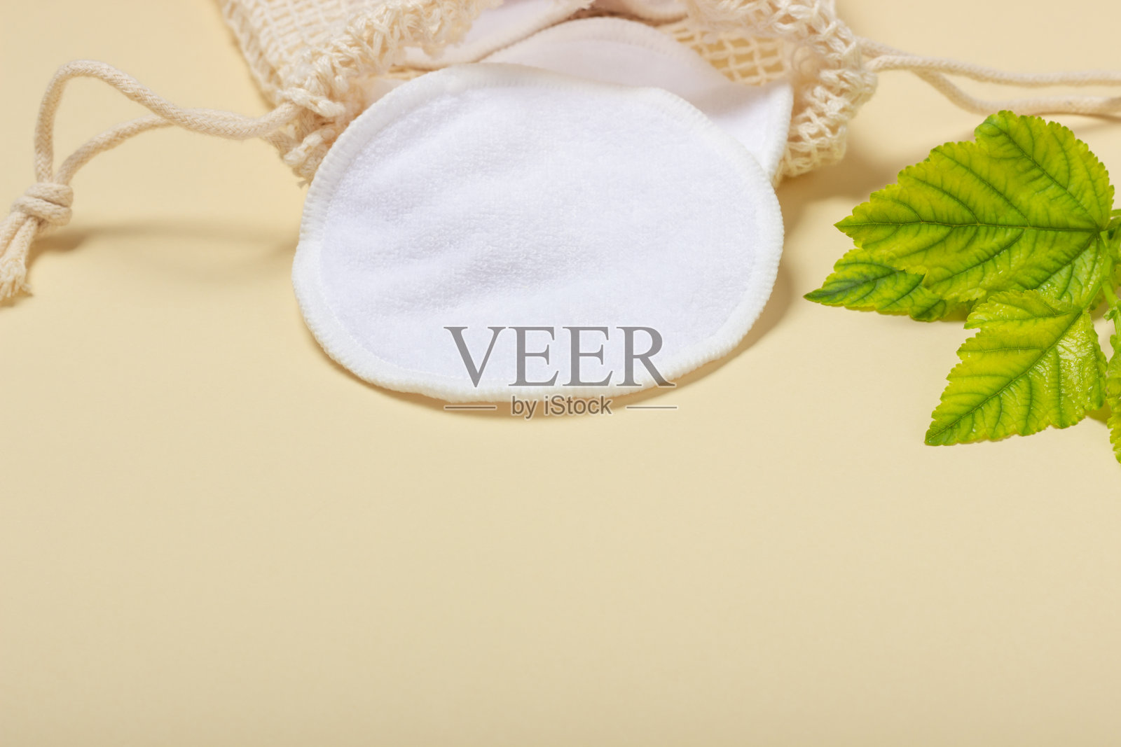 可重复使用的化妆卸妆棉垫在布袋在米色背景。生态观念与自觉消费。可重用的棉花垫照片摄影图片