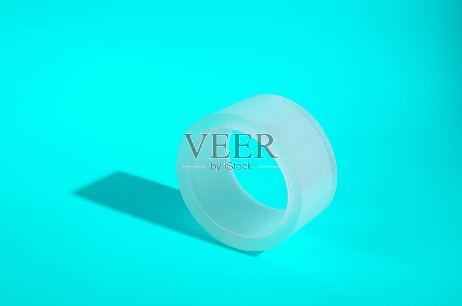 透明胶带缠在绿松石色的背景上照片摄影图片